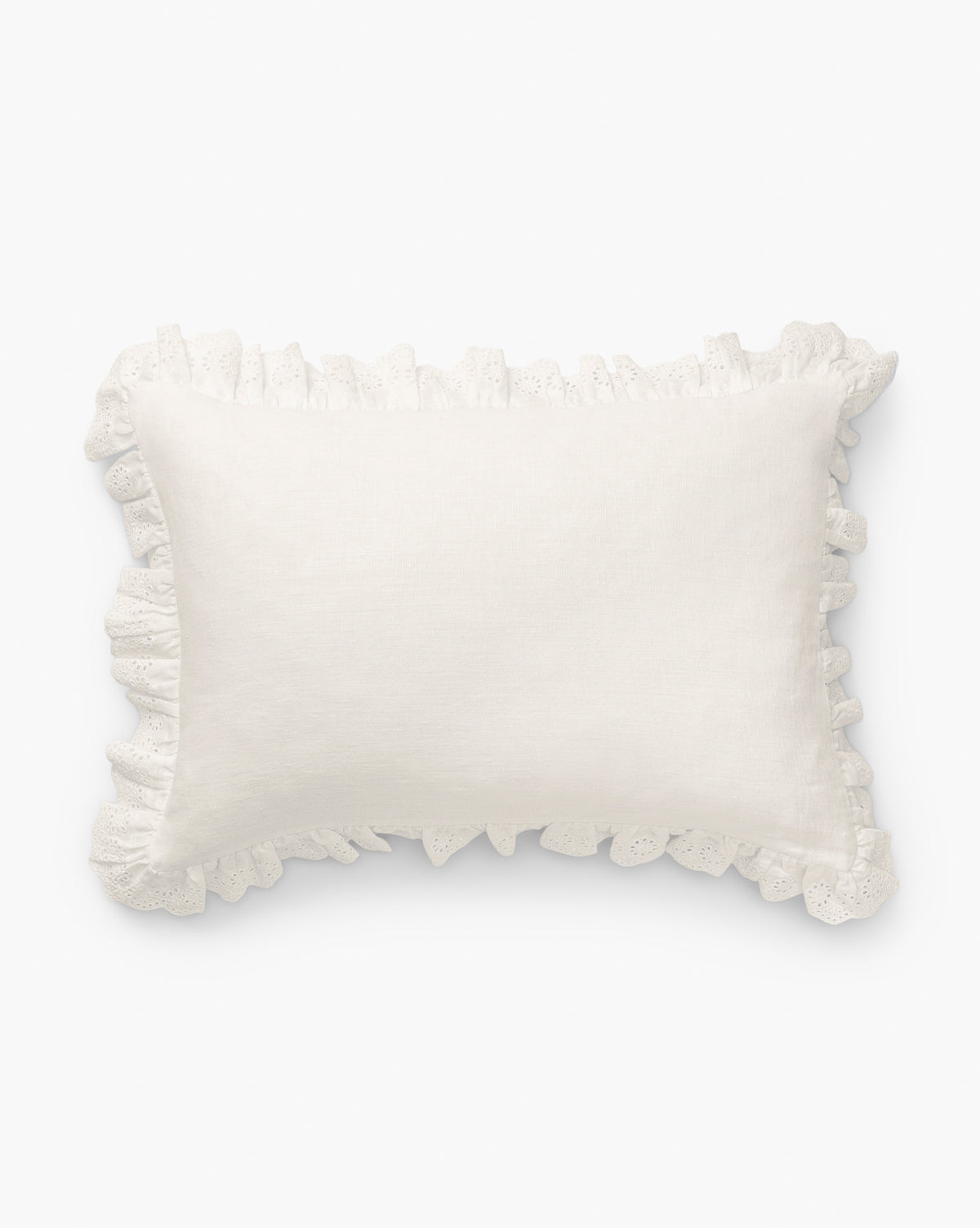 The McGee & Co. x Loeffler Randall Delilah Broderie Trim Pillow Cover features a textured white linen surface with decorative ruffled broderie trim, capturing the signature Loeffler Randall style against a crisp white backdrop, by McGee & Co.