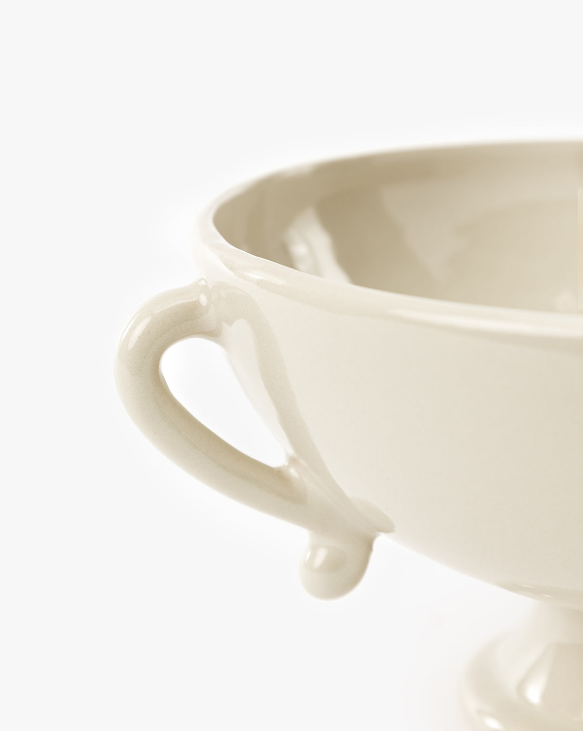 Close-up of the Delphine Footed Bowl, a cream-colored ceramic piece with a handle, set against a plain white background, by McGee & Co.