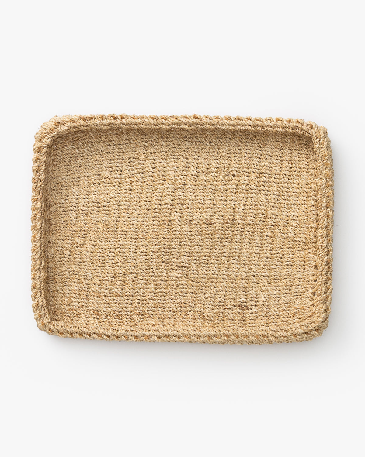 The Deryn Woven Tray features a rectangular shape, raised edges, and textured natural abaca fiber—ideal as a coffee table tray. Shown on a white background.