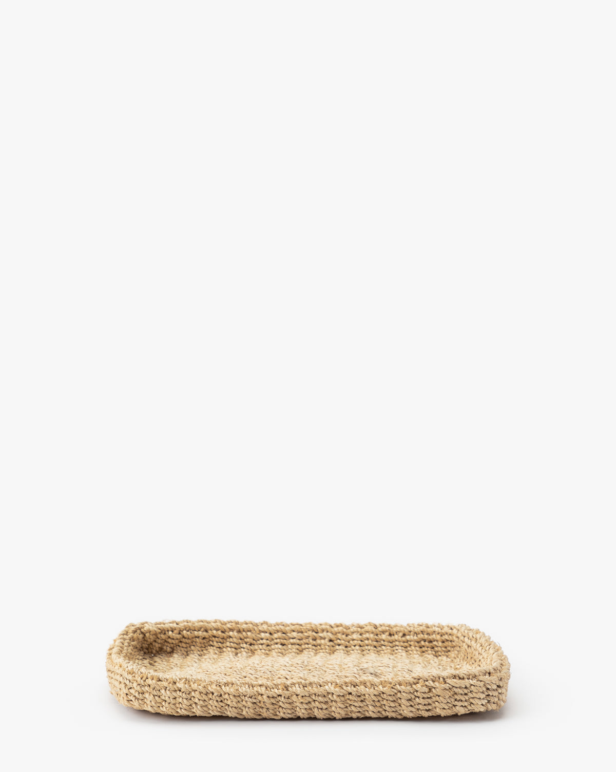The Deryn Woven Tray is a rectangular, shallow tray crafted from natural abaca fibers, ideal for use as a coffee table tray and shown here against a plain white background.