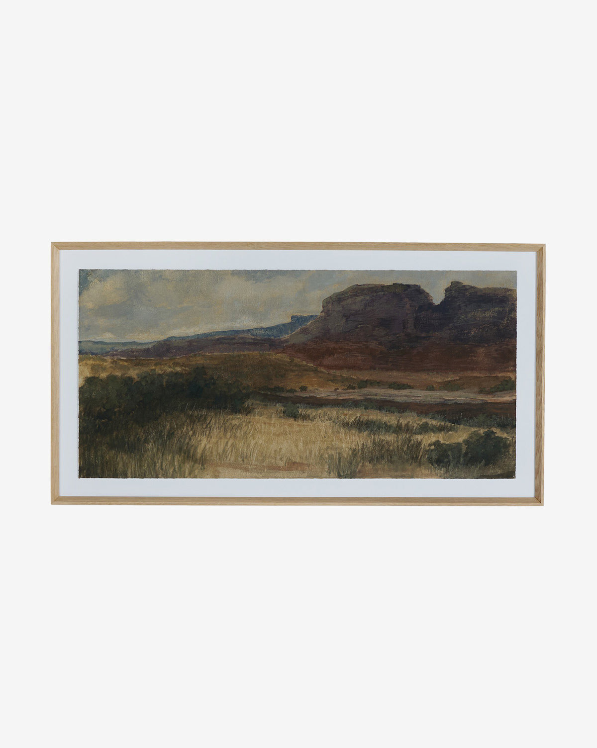 Desert Hues I by Aileen Fitzgerald is a framed white oak landscape print on fine art paper, showcasing grassy plains and rocky mesas under a cloudy sky in earthy greens, browns, and blues for vibrant, lasting detail, by McGee & Co.