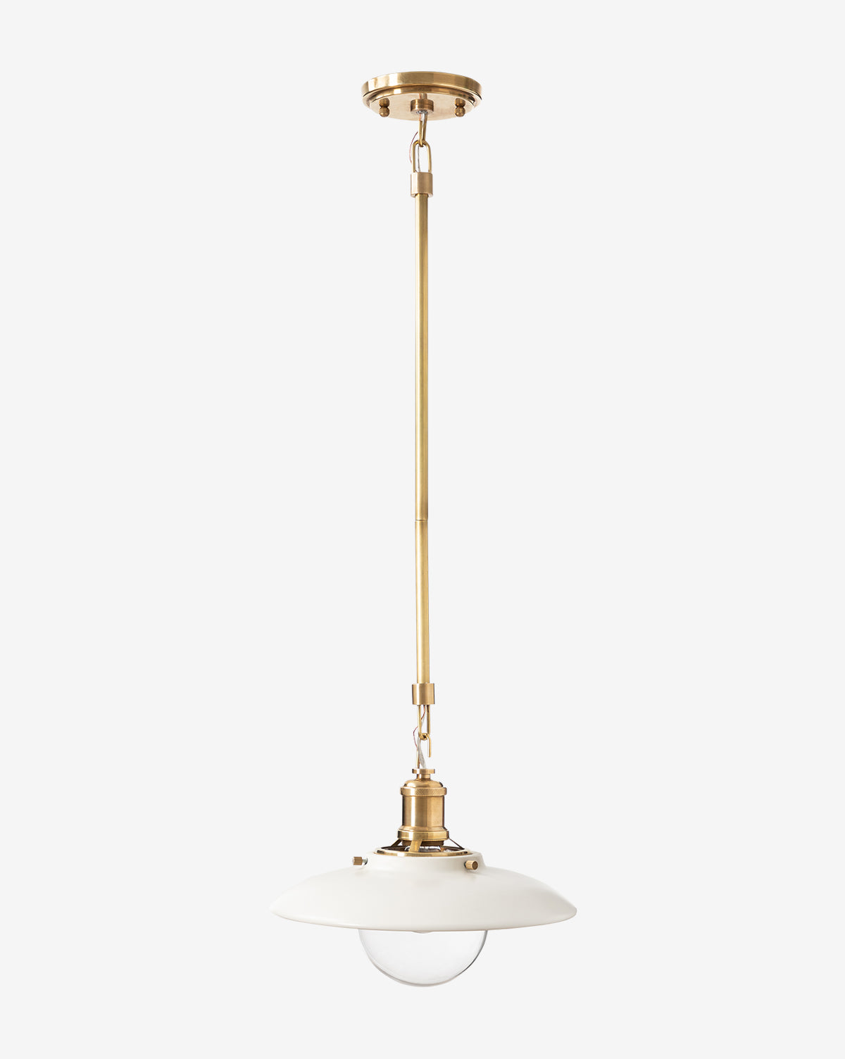 The Didier Ceramic Pendant features an antique brass rod, white round ceramic shade, and exposed glass bulb, hanging from a brass ceiling mount against a plain background, by McGee & Co.