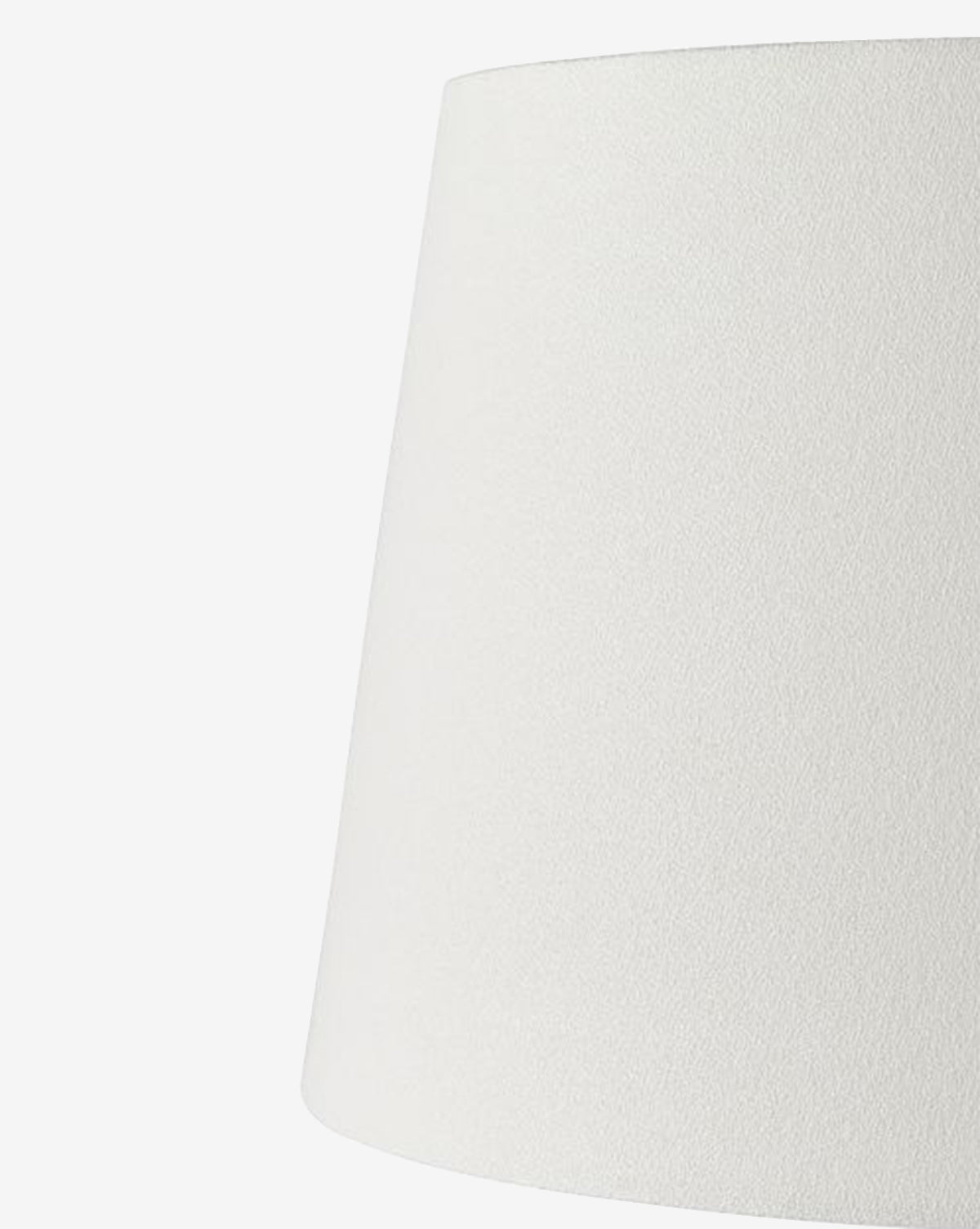 A close-up view of the Django Table Lamp’s plain white linen shade, featuring a subtly textured surface against a white background. Only the upper section and side of the lampshade are visible, by McGee & Co.