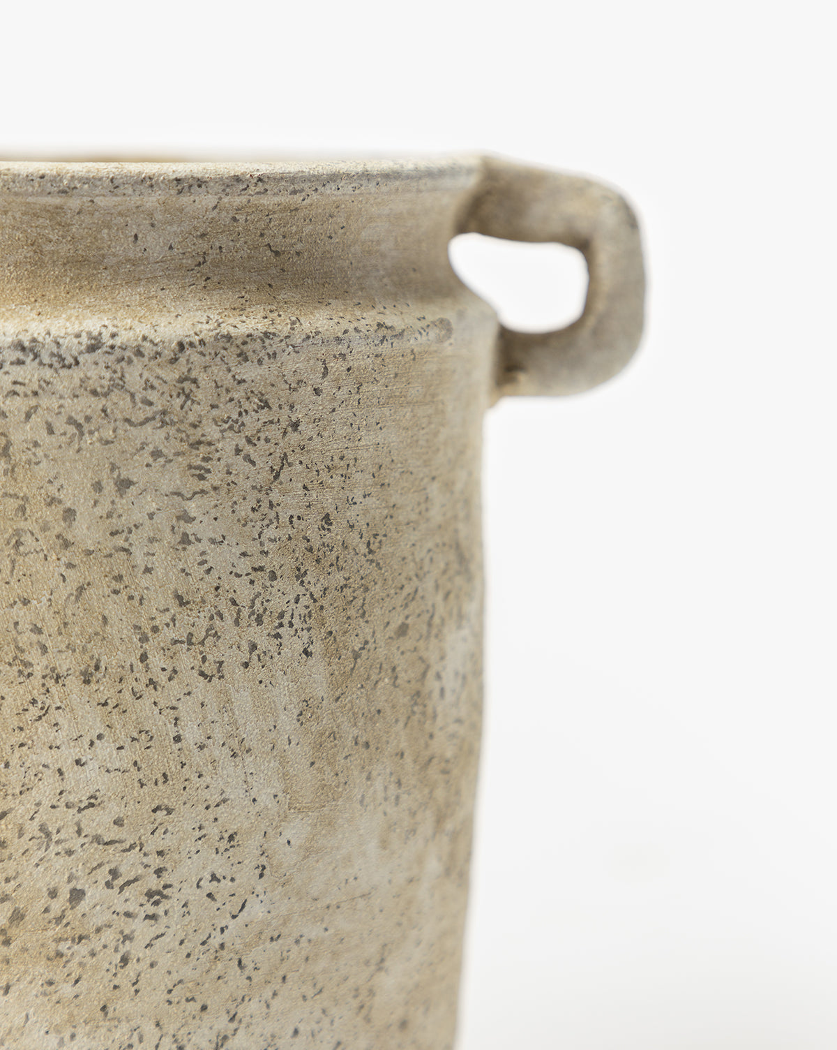 Close-up of the Dual Handled Vase, featuring a speckled beige ceramic texture and one visible angular handle, set against a plain white background. Only part of this vintage-inspired vase and its handle are shown.
