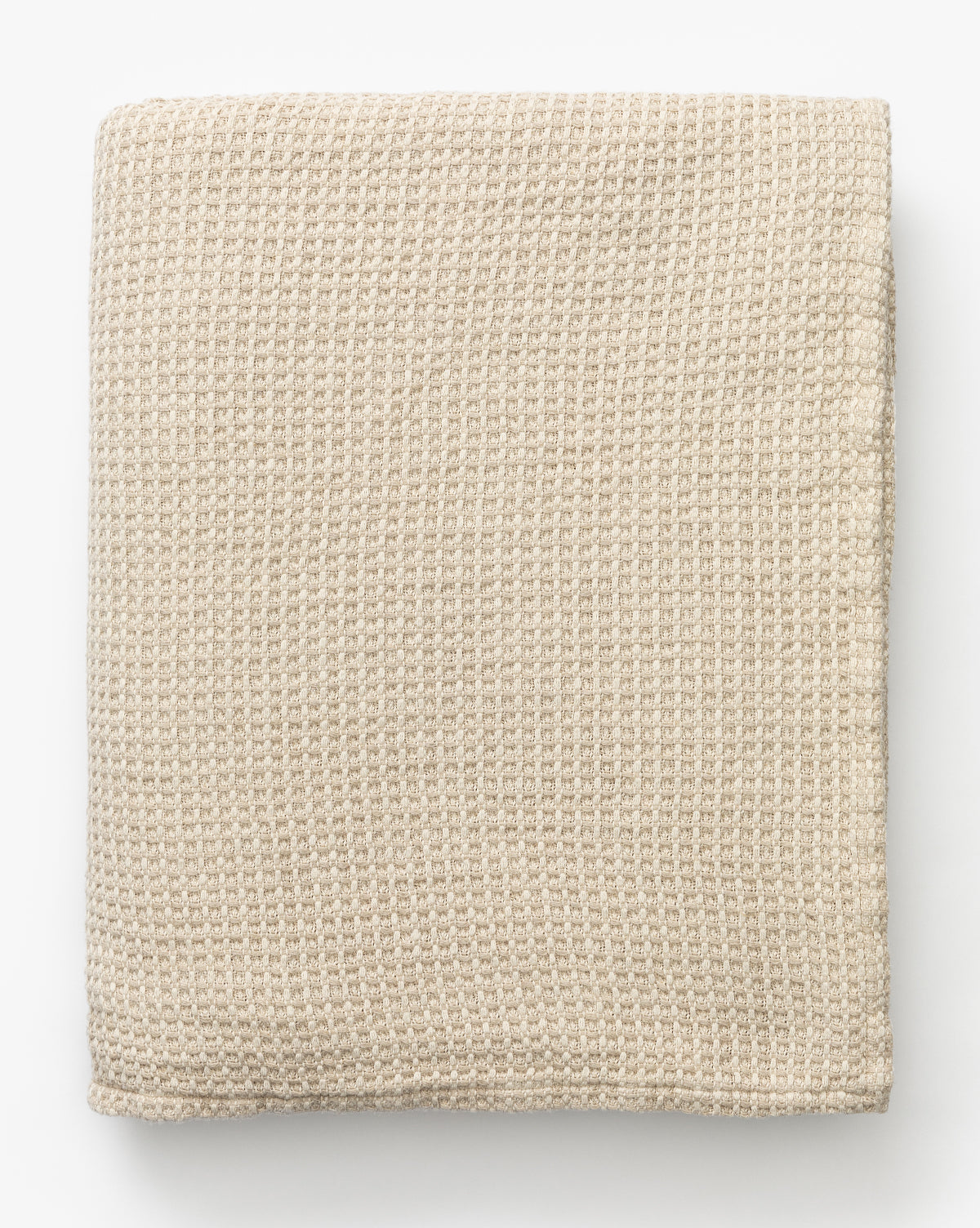 The Penedo Duffy Oversized Throw, in beige waffle-knit fabric, sits neatly folded on a white background. Its textured pattern adds to the blanket’s cozy and soft look. McGee & Co.