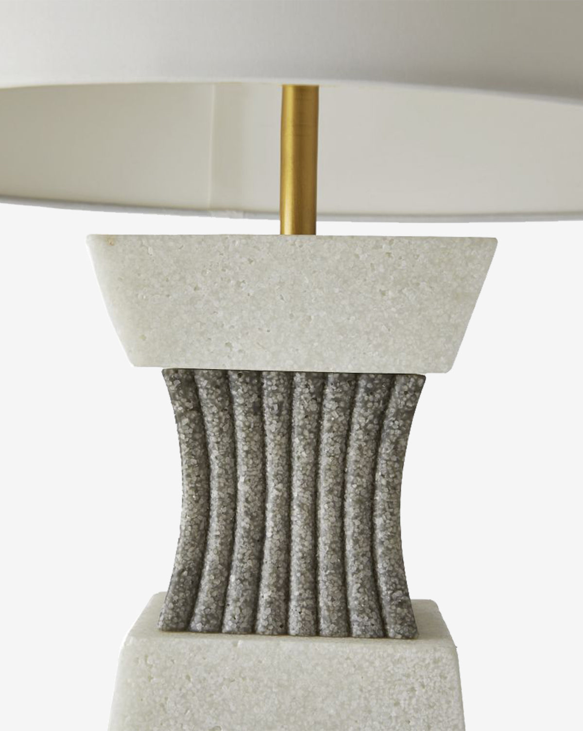 The Dynasty Table Lamp showcases a white stone base, a gray ribbed center, and a gold metal stem, all topped with a tapered off-white shade, by McGee & Co.