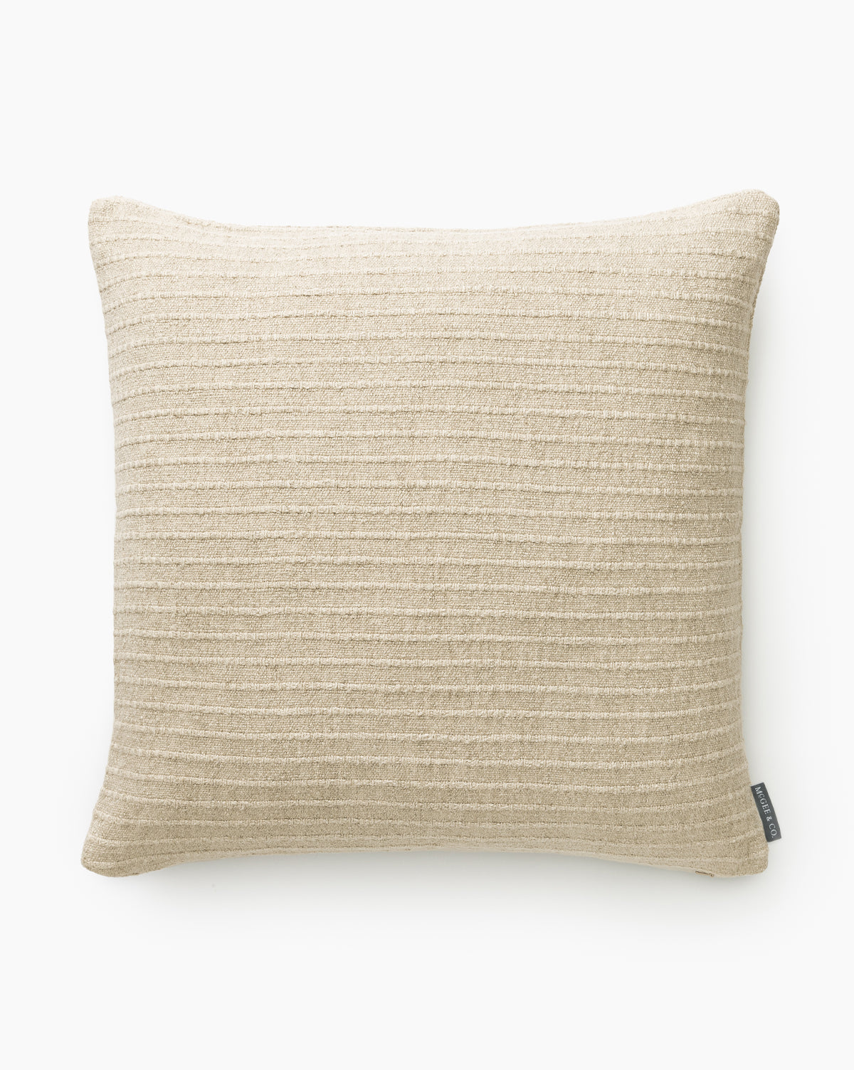 The Eaton Pillow Cover is square, made from a cotton-linen blend in neutral tan with subtle horizontal stripes, by McGee & Co. Displayed on a white background, it has a small fabric tag on one side.