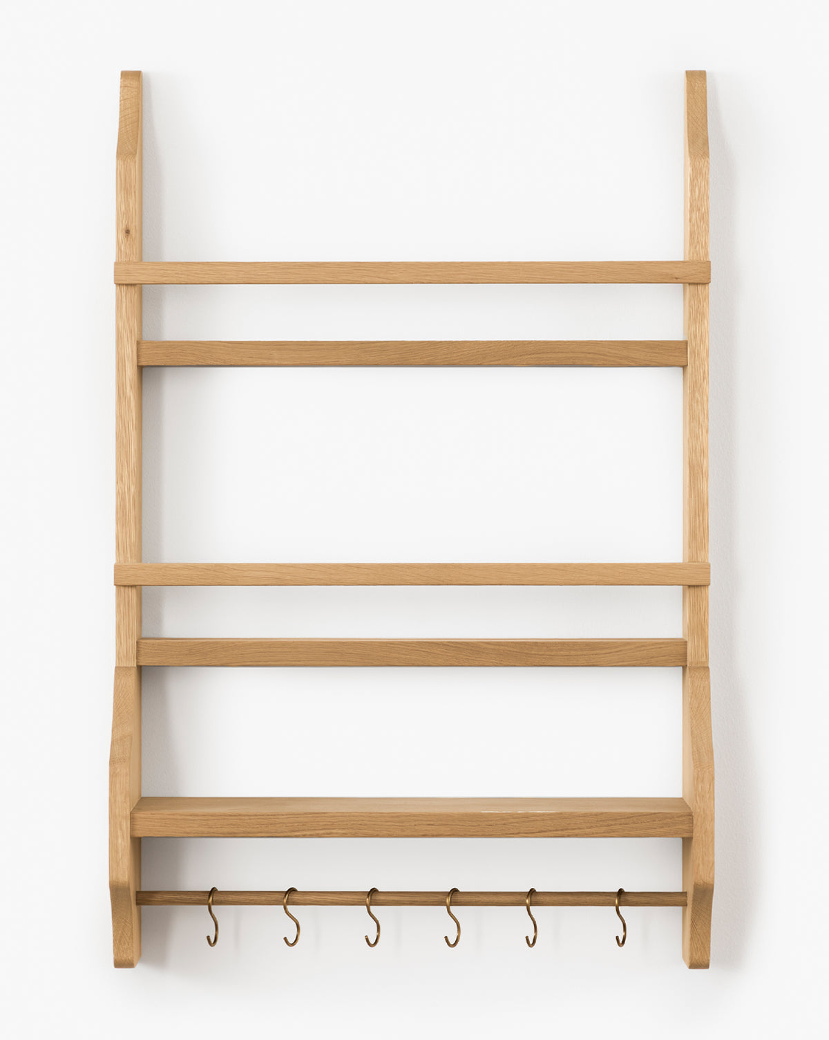 The Edna Kitchen Shelf is a heritage oak wall-mounted unit with four open shelves and five metal hooks underneath, shown against a white background, by McGee & Co.