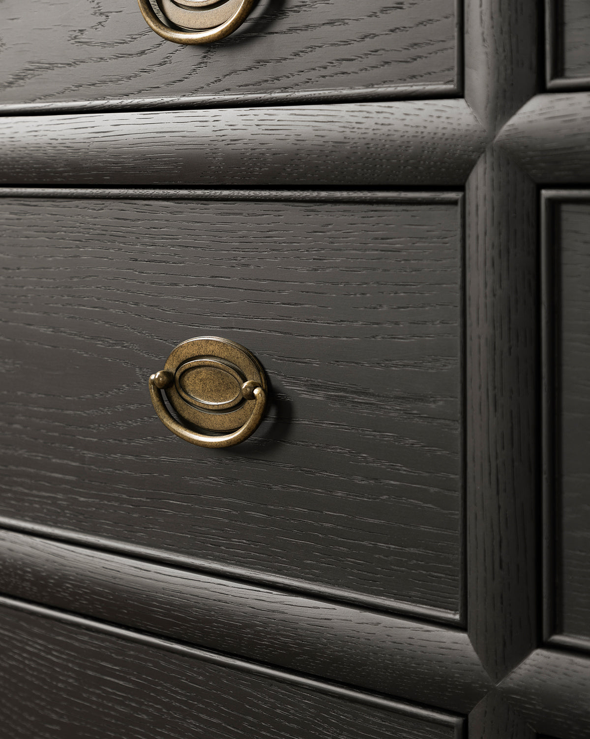 Close-up of the Edward Dresser in Black Ash finish, showcasing textured grain, round brass drawer pulls, and raised rectangular panel details—a stylish storage solution for bedrooms, by McGee & Co.