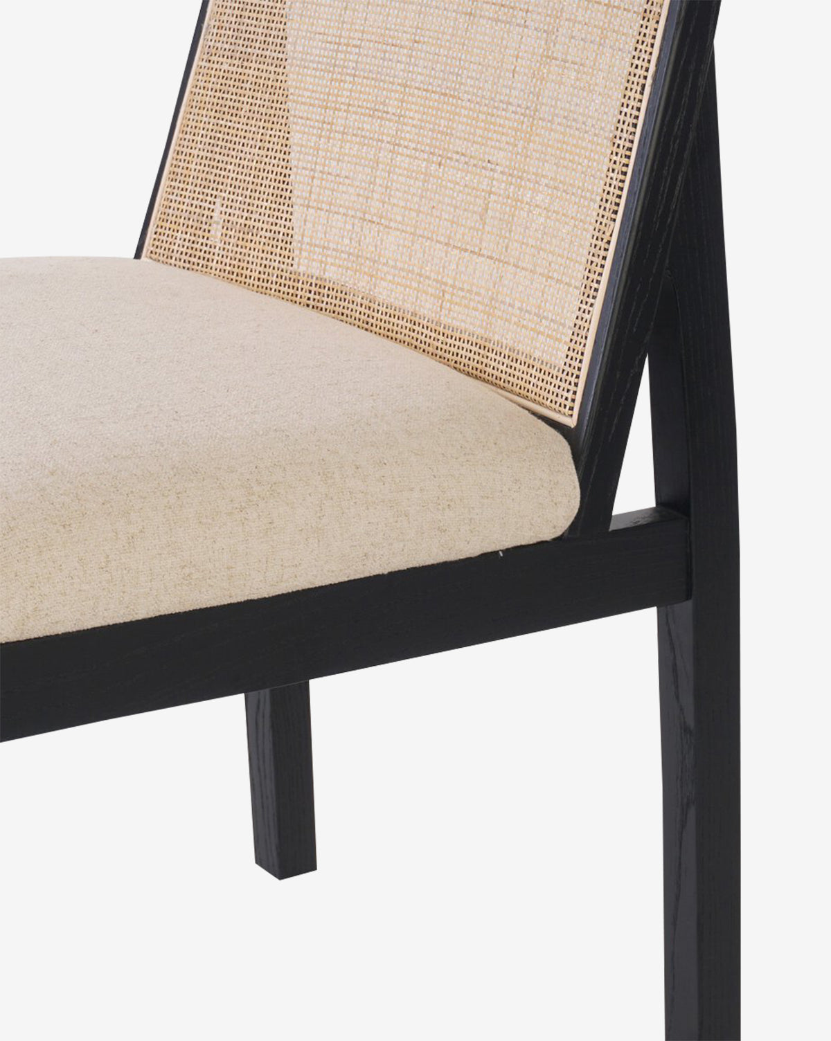 A close-up of the Eira Dining Chair showcasing its black wooden frame, beige performance fabric seat, and elegant cane backrest, set against a plain white background by McGee & Co.