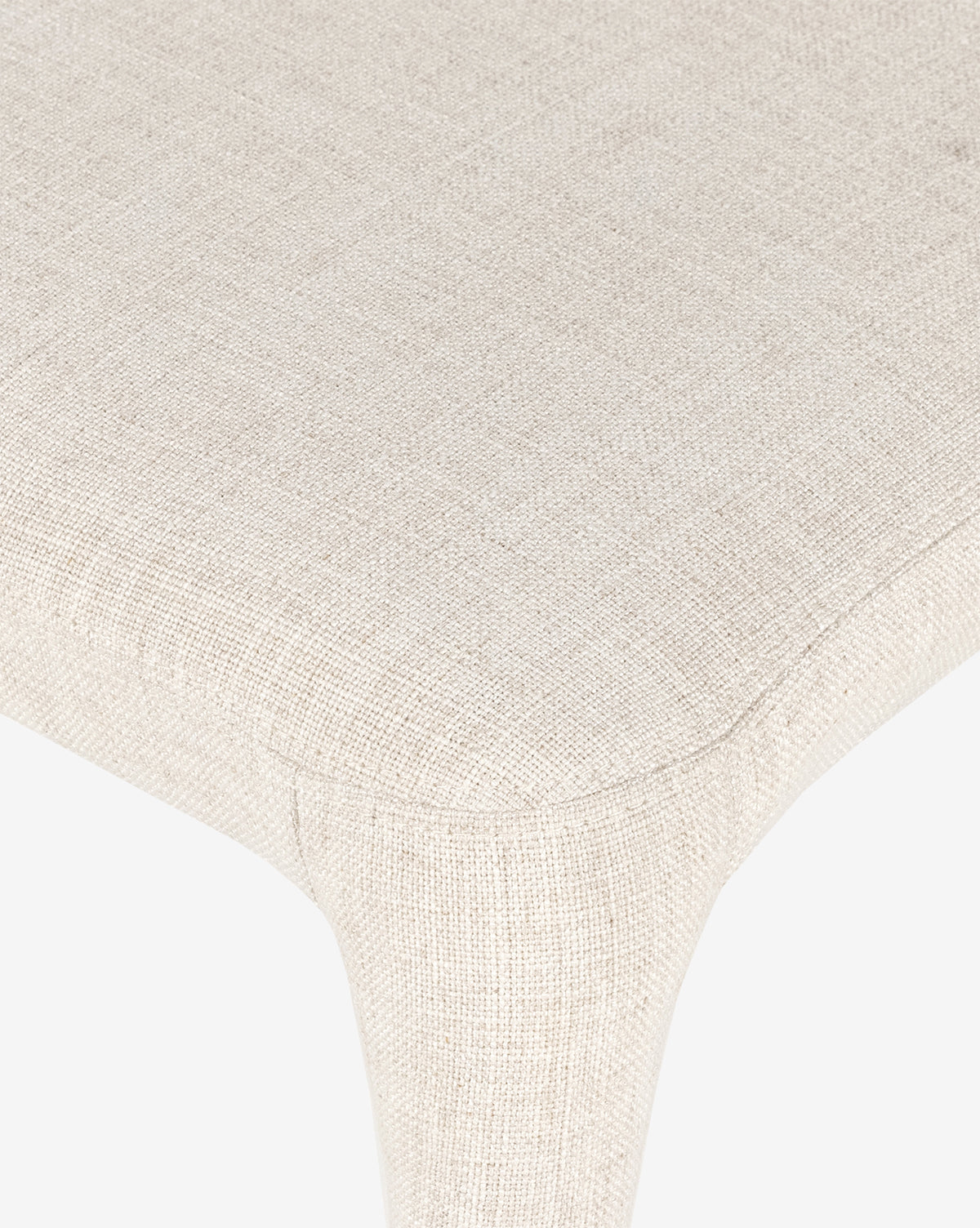 Close-up of the Elbert Dining Chair’s beige, textured flax linen seat highlights detailed stitching and its curved edge against a white background, by McGee & Co.