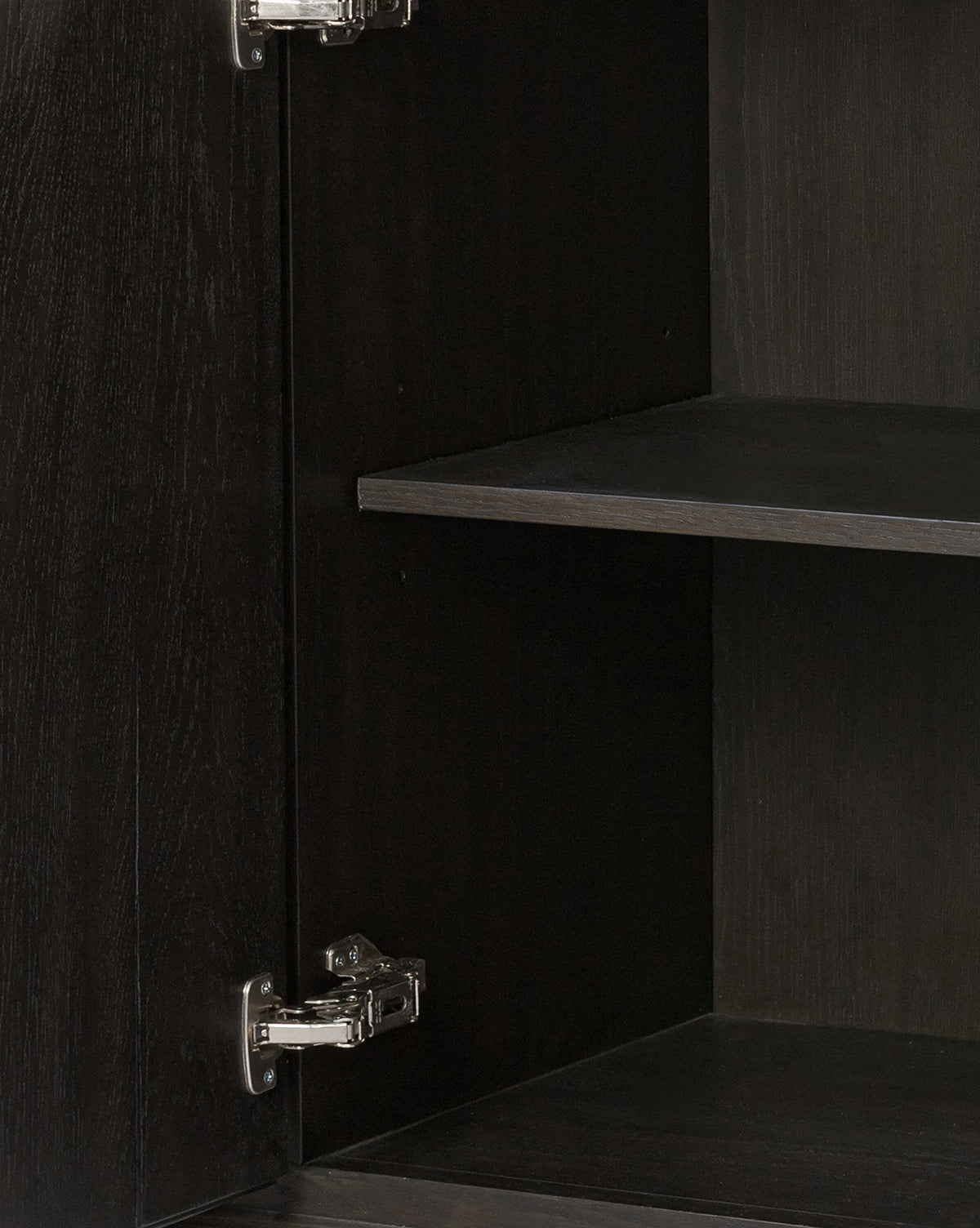 Close-up of the Eldoria Oak Sideboards interior in black oak, featuring two metal hinges on the left and two empty shelves—a sleek modern deco furniture piece, by McGee & Co.