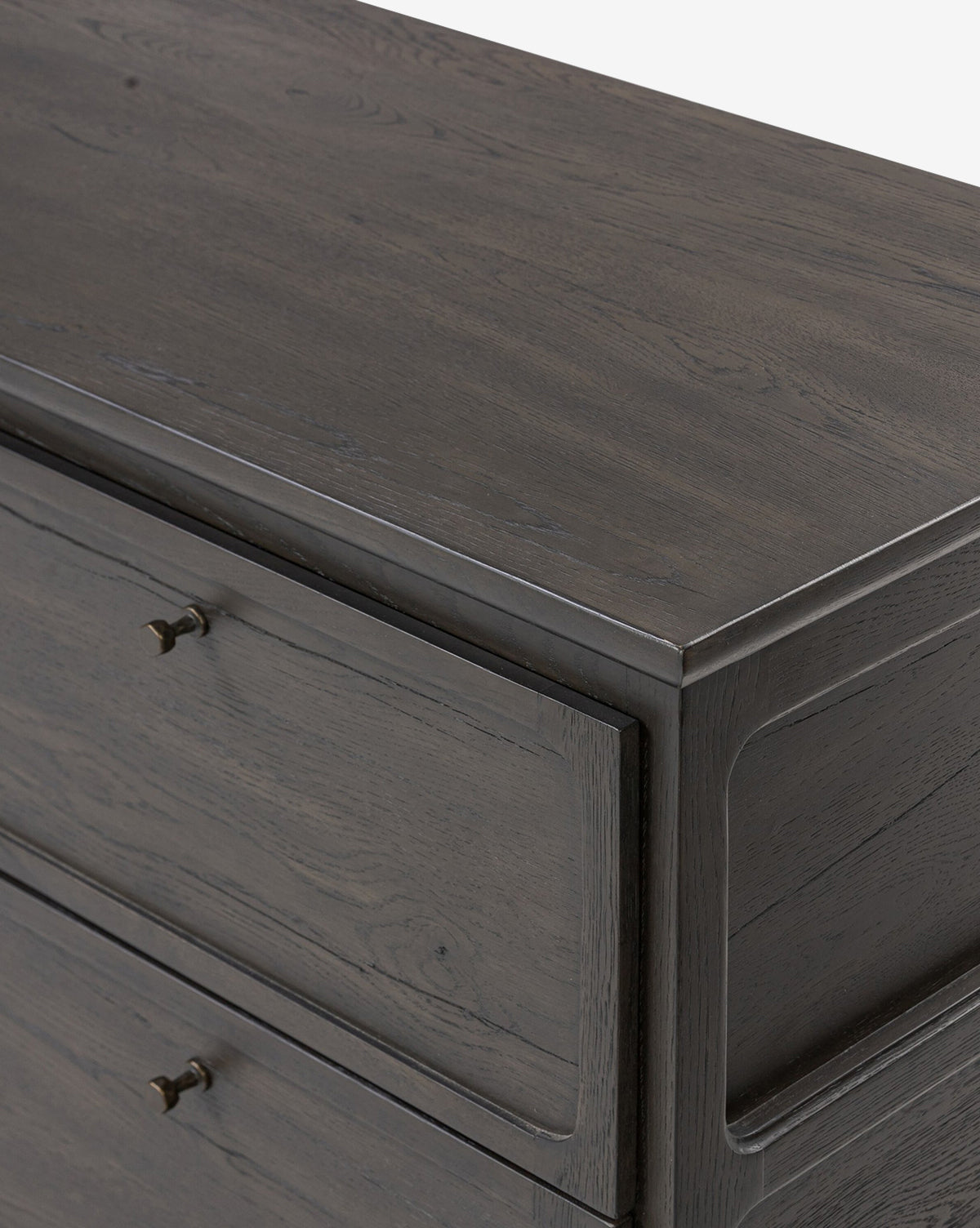 Close-up of the top corner of the Eldoria Oak Sideboard in black with visible grain, two drawers, and small round metal pulls, set against a plain white background—a modern deco accent piece, by McGee & Co.