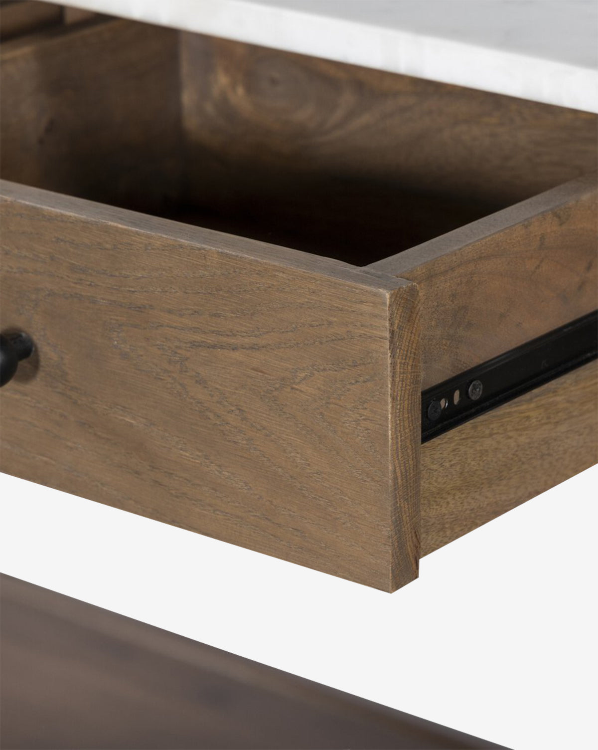 A close-up of the Eldric Kitchen Island reveals its solid oak base, open wooden drawer with a metal handle, black metal slide mechanism, and a sleek white marble tabletop, by McGee & Co.