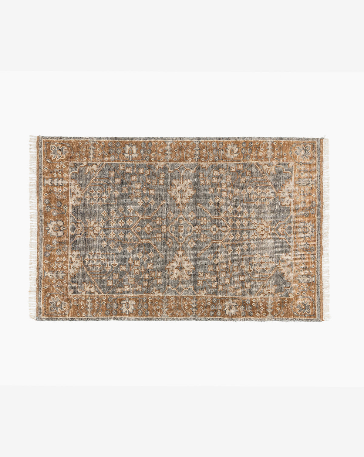 The Elison Hand-Knotted Wool Rug showcases intricate floral and geometric patterns in muted blue and tan, artisan-crafted borders, and short fringe on the shorter sides, by McGee & Co.