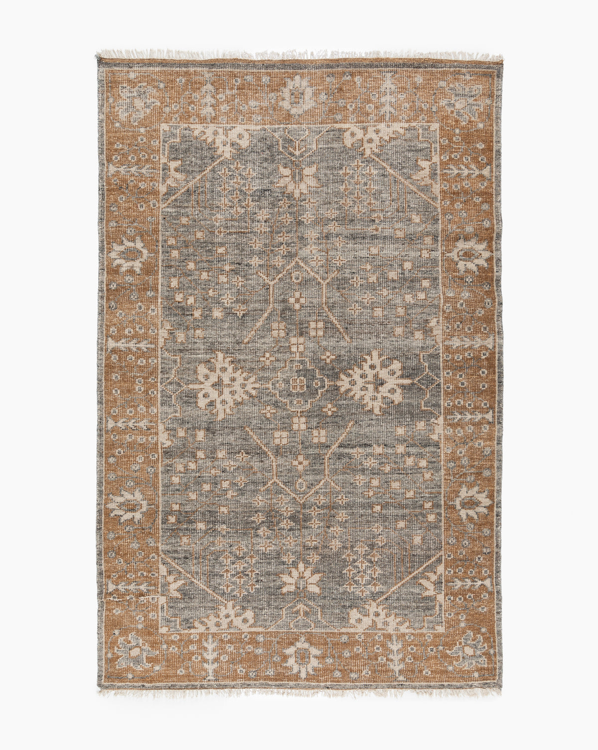 The Elison Hand-Knotted Wool Rug features a gray central field with intricate floral and geometric patterns, a wide tan border with similar artisan details, and fringed edges that highlight its traditional textile charm, by McGee & Co.