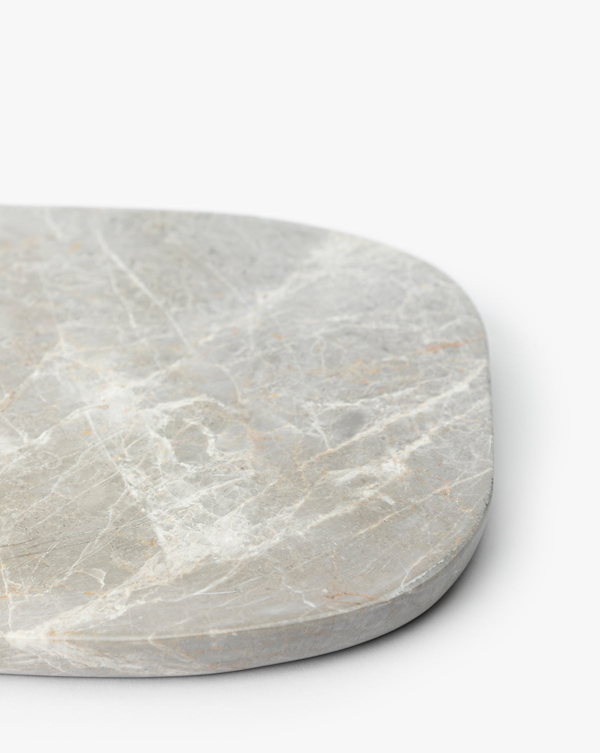 A close-up of the Eliza Marble Tray, a smooth, rounded rectangular decorative piece crafted from light gray marble with white veining, photographed against a plain white background, by McGee & Co.