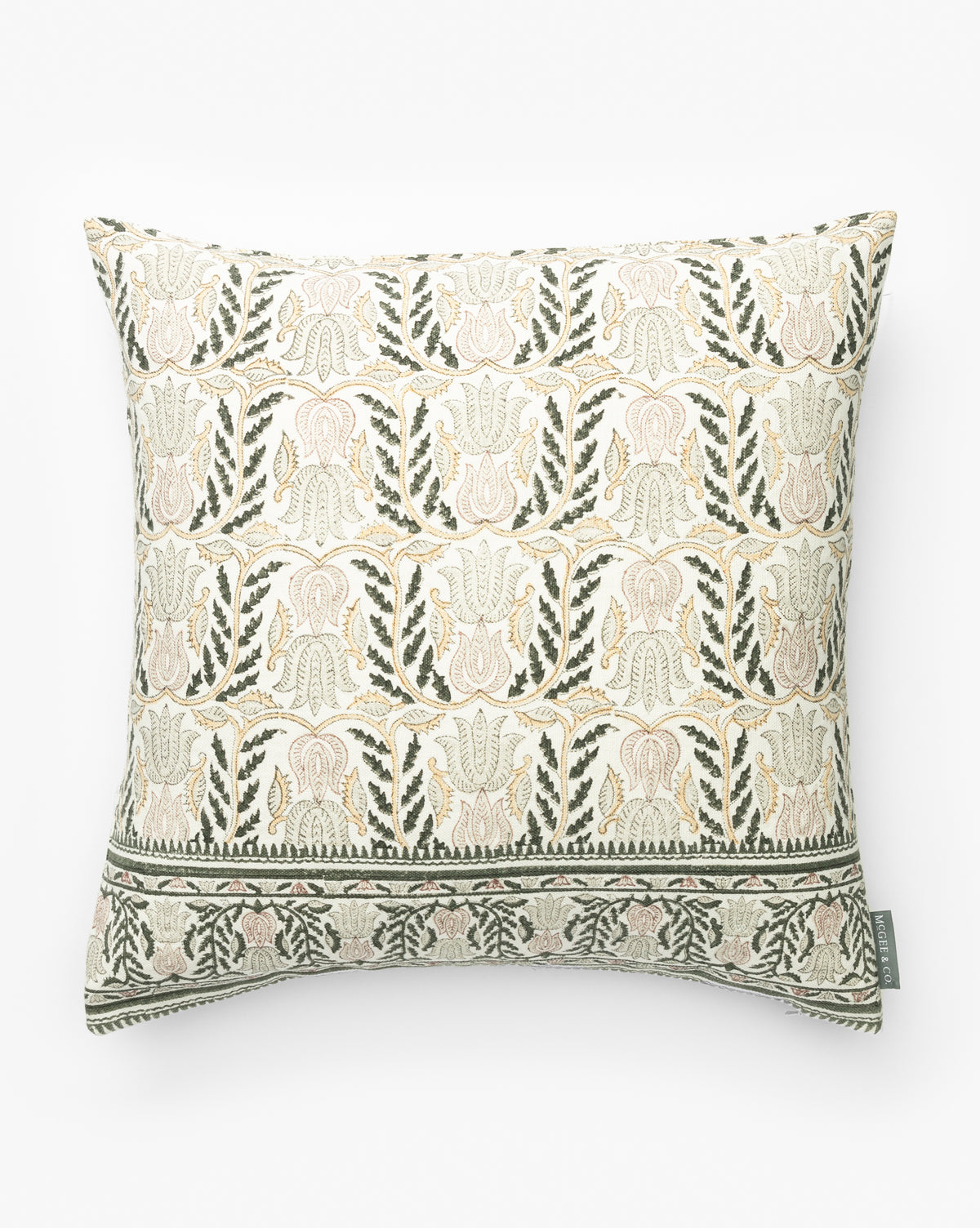 The Ellsbeth Pillow Cover features a beige background with an intricate floral and leaf block print in muted green and soft pink, plus a decorative border on one edge and a small fabric tag, by McGee & Co.