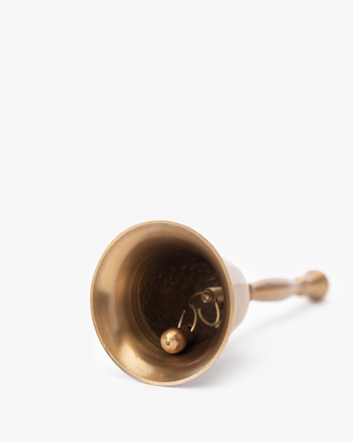 The Elsher Bell, a small antique brass bell with classic styling, rests on its side showing the clapper and handle—perfect for vintage decor against a plain white background, by McGee & Co.