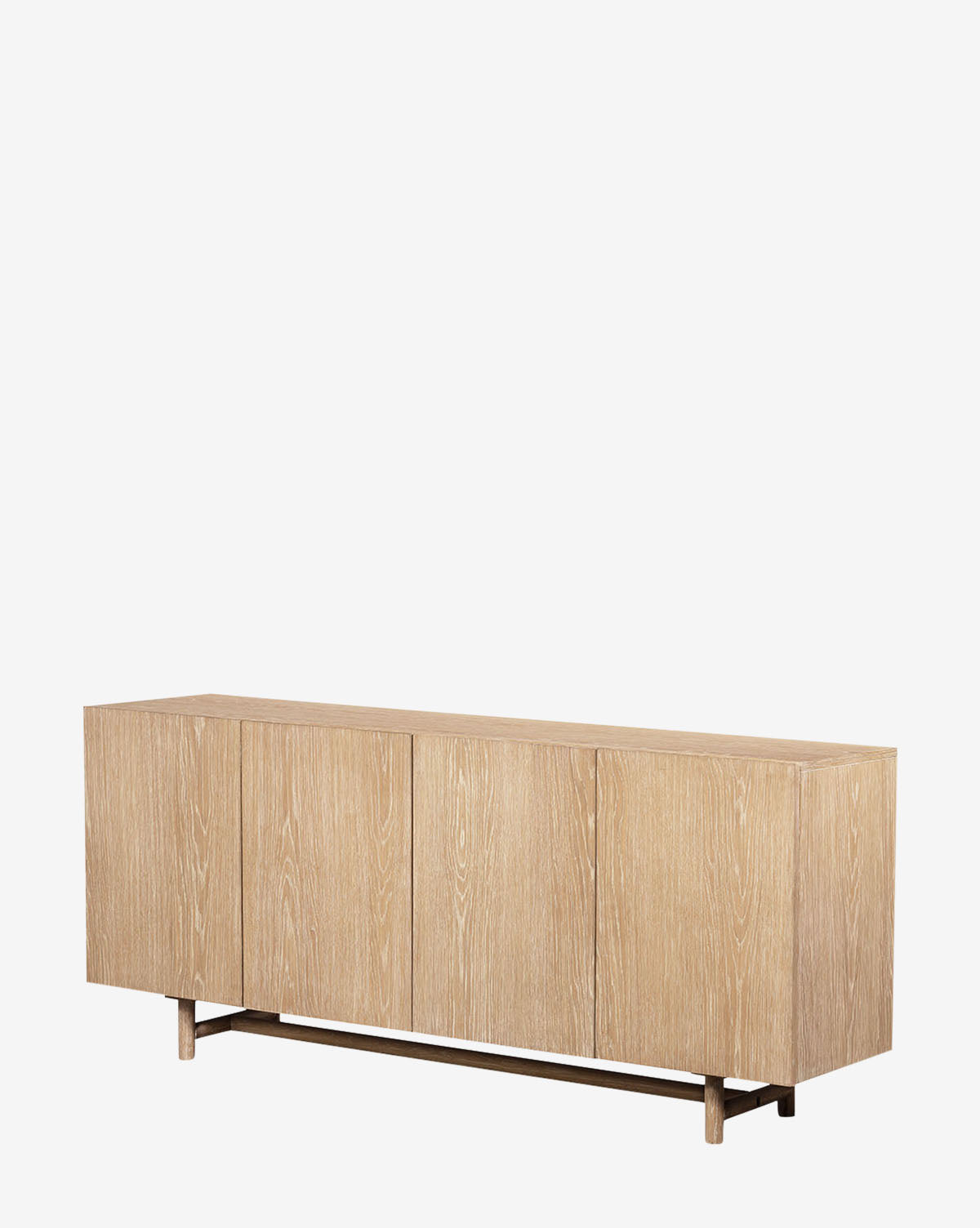 The Emilee Sideboard is a modern rustic piece crafted from light, whitewashed oak. Featuring four doors, clean lines, and a minimalist matte finish, this rectangular cabinet sits on short legs against a plain white background by McGee & Co.