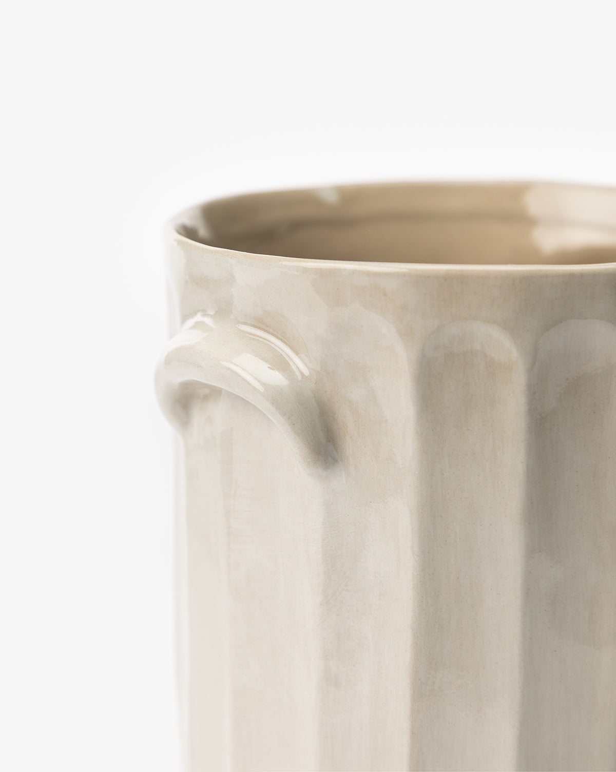 Close-up of the Emilia Crock, a beige ceramic vase with a glossy finish, vertical ridges, and a small curved handle, set against a plain white background—ideal for any kitchen countertop.