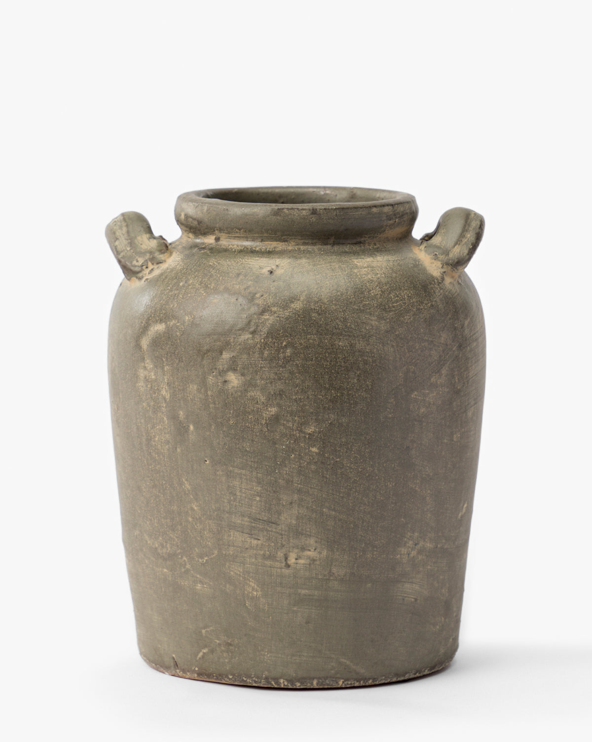 The Emilio Urn is a rustic olive-green ceramic jar with a rough texture, a wide cylindrical body, and two small top handles—an elegant shelf accessory ideal for vintage decor—set against a plain white background, by McGee & Co.
