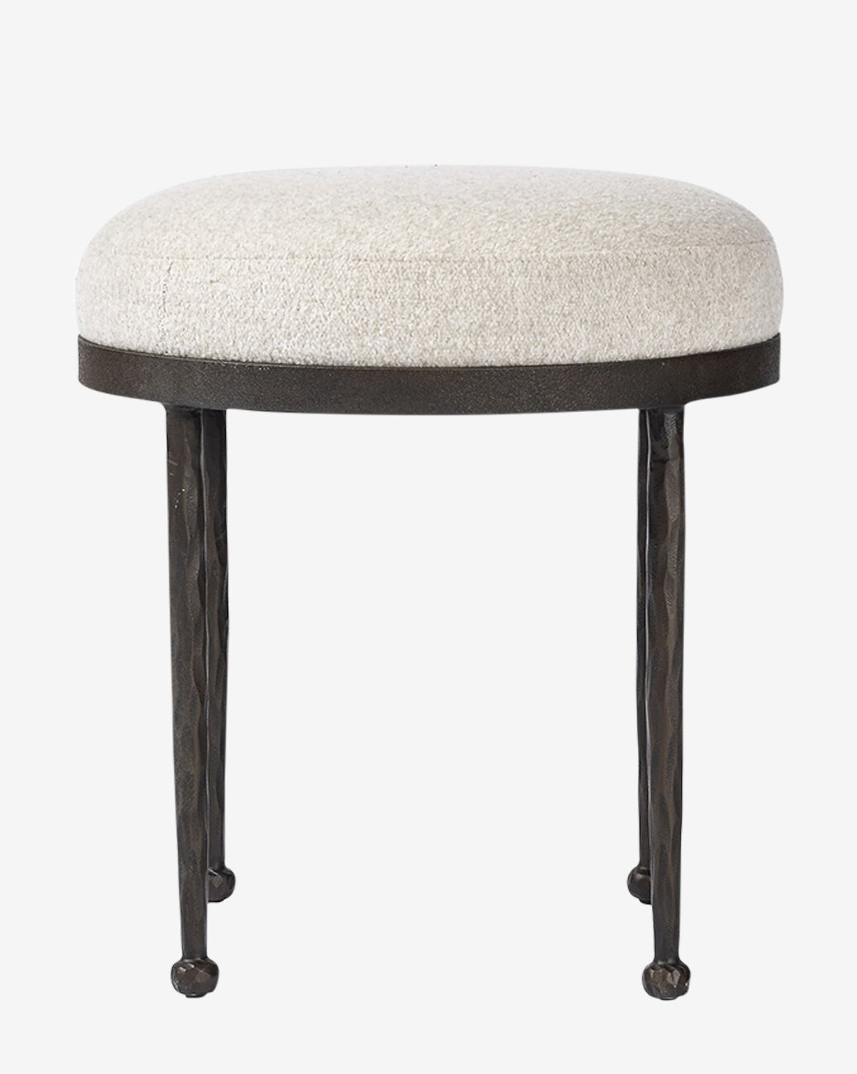 The Emmett Stool by Four Hands is a small, round accent piece with a cushioned light beige upholstered seat and three slender, textured black metal legs by McGee & Co.