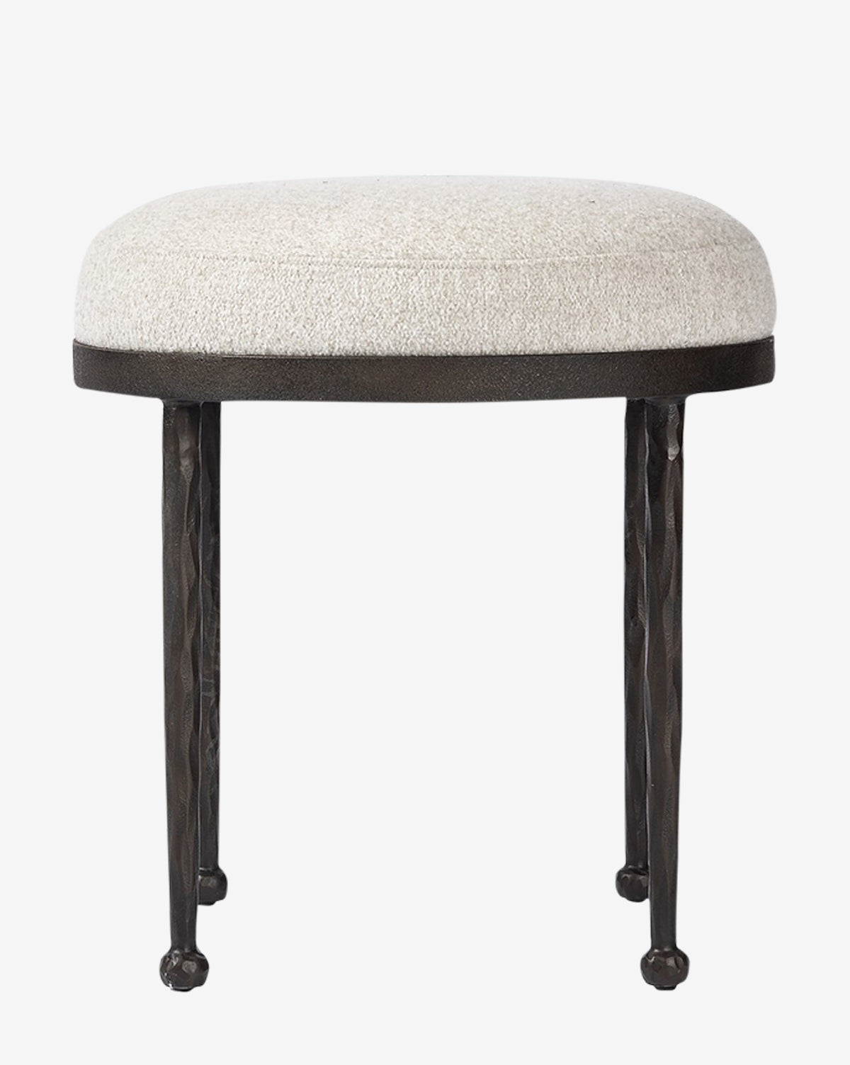 The Emmett Stool by Four Hands features a small, round design with a light beige upholstered cushion and three textured black metal legs, making it an ideal accent piece against a plain white background. McGee & Co.