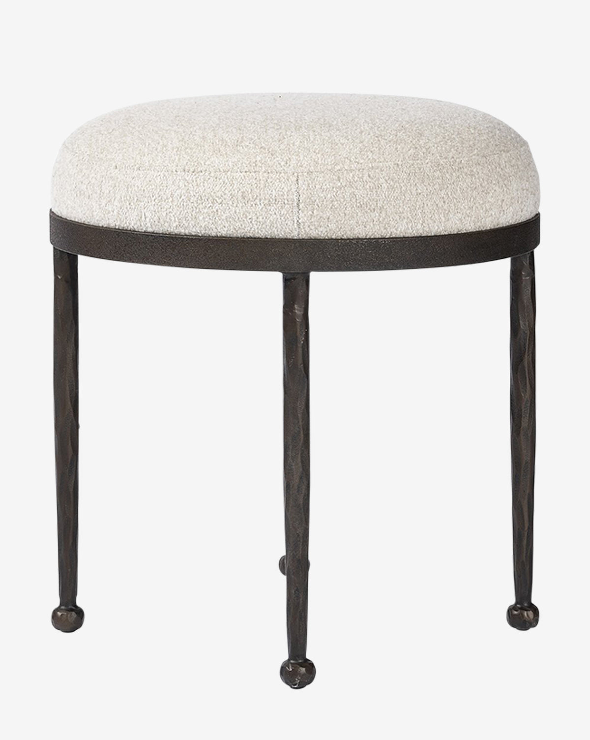 The Emmett Stool by Four Hands features a round, light beige cushioned seat atop three slender black metal legs. Its minimalist design and subtly textured finish bring modern style to any space. McGee & Co.