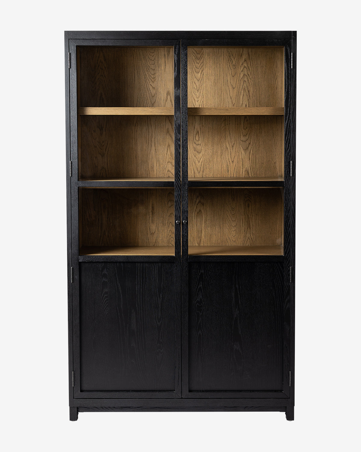 The Emrys Cabinet is a tall, black wood piece with glass and oak doors on top showing three shelves, and solid lower doors for storage, all set against a plain white background, by McGee & Co.