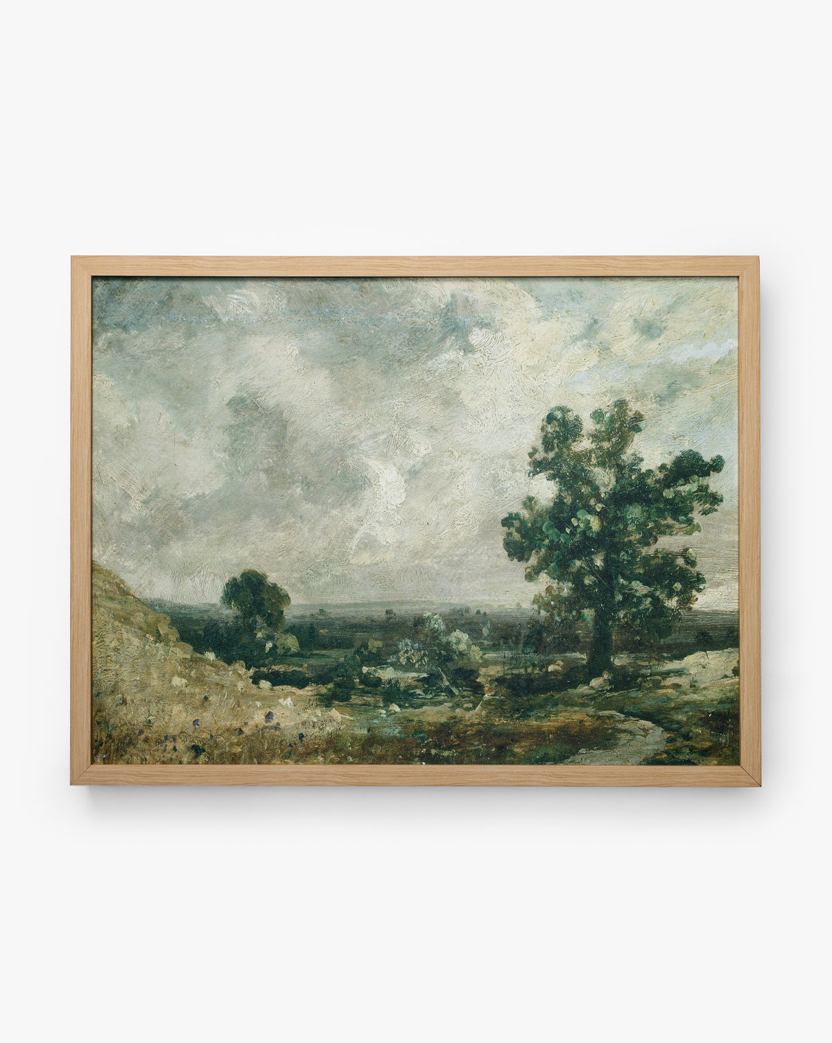 English Meadows: A framed landscape painting with a cloudy sky, green trees, grass, and a dirt path in muted colors, set in a natural wood oak frame, by McGee & Co.