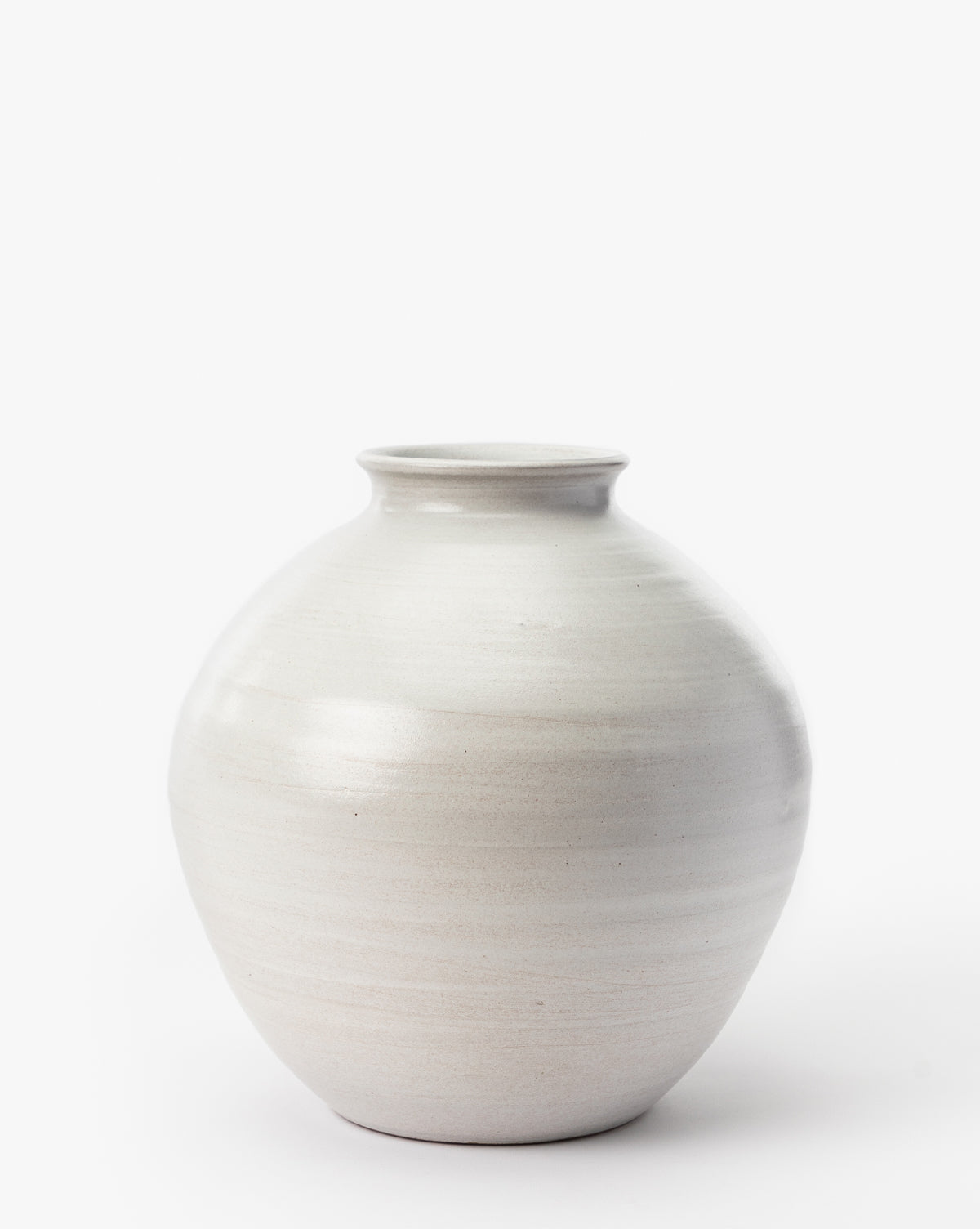 The Enola Vase is a round, off-white stoneware vase with a smooth matte finish and a small flared opening, perfect for home decor. Shown against a plain white background.