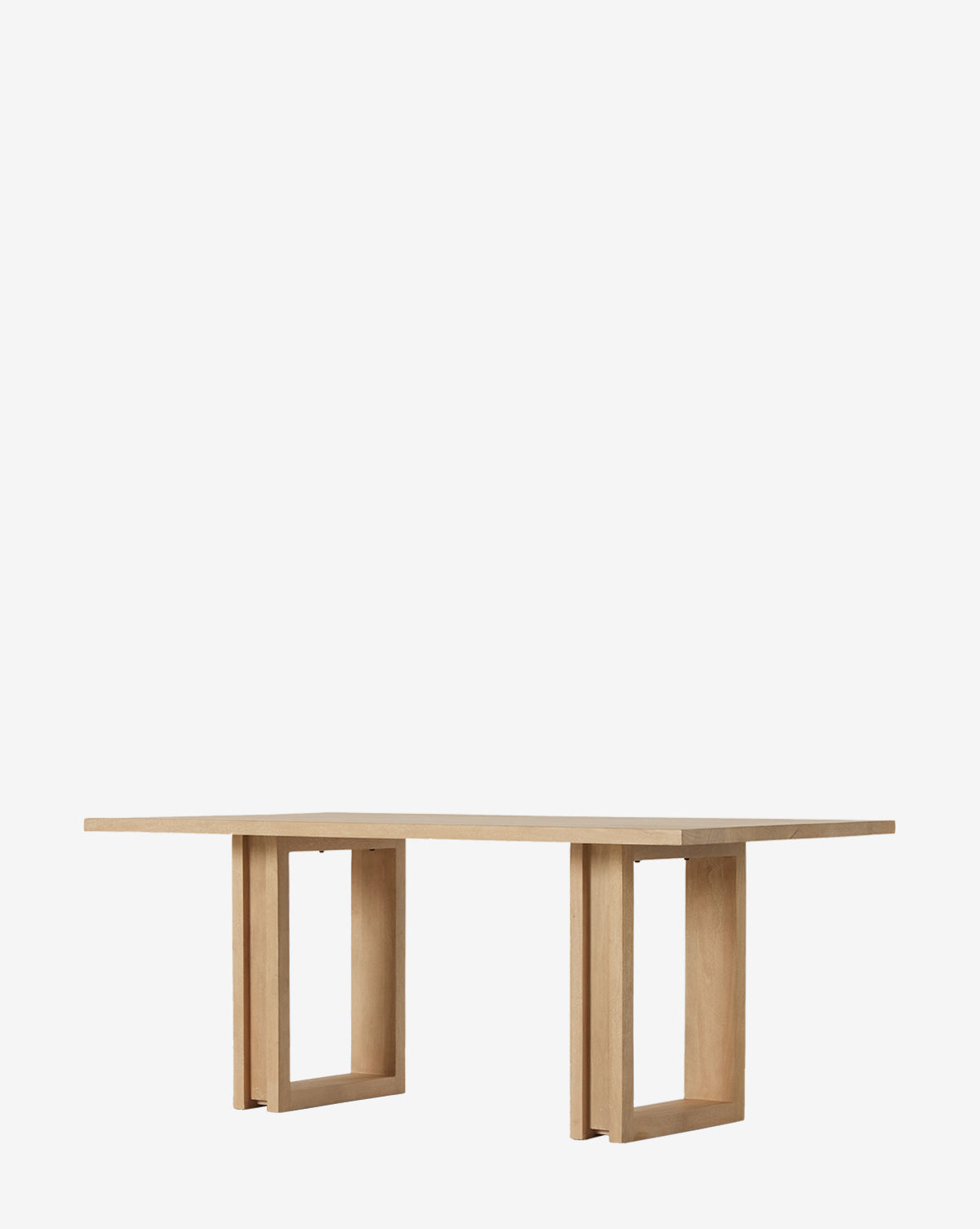 The Ernie Dining Table features a rectangular solid mango wood top and two geometric open-frame legs at either end, offering a minimalist modern look, by McGee & Co.