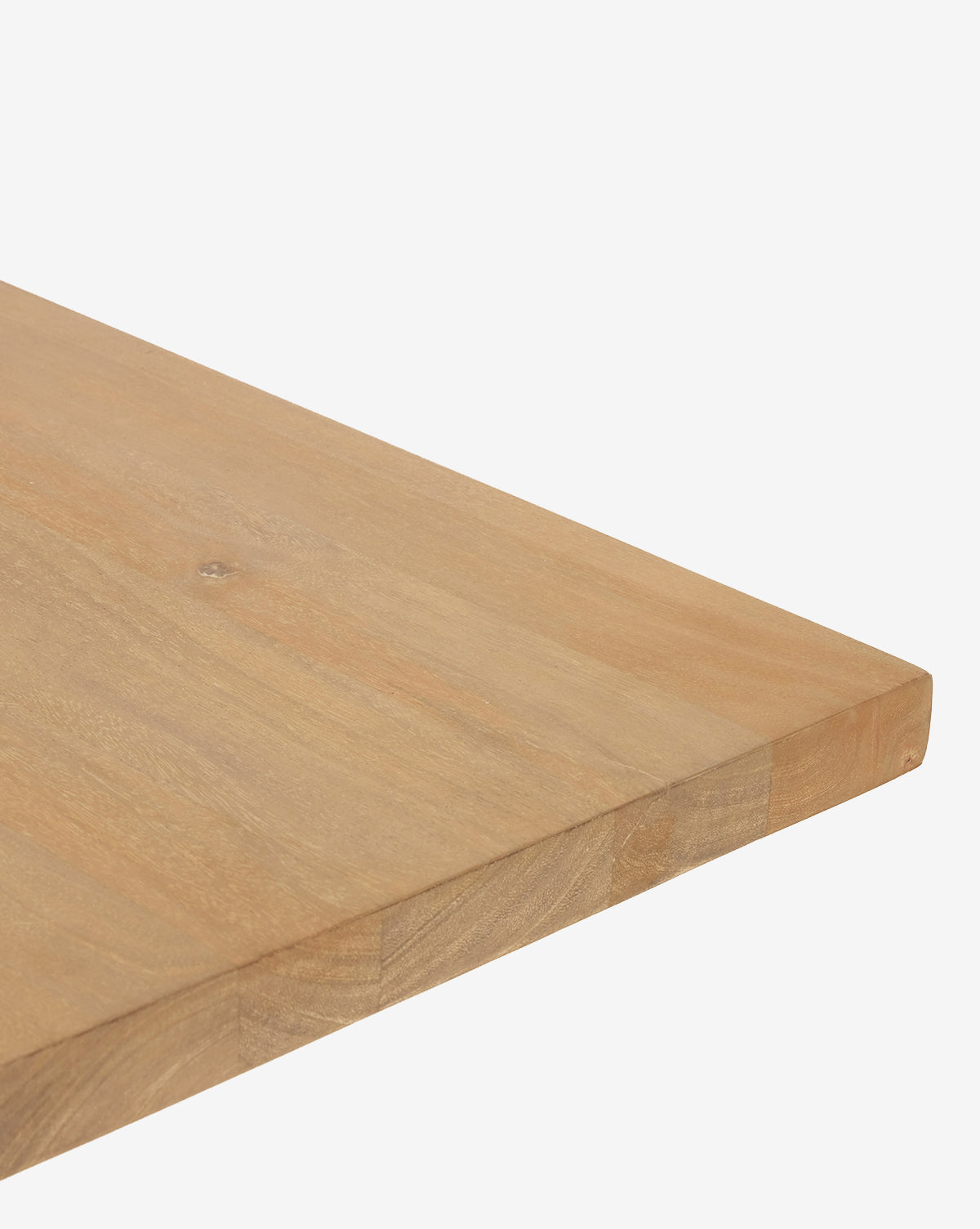 A close-up of the Ernie Dining Table’s corner, highlighting its solid mango wood construction and smooth natural finish, set against a white backdrop by McGee & Co.