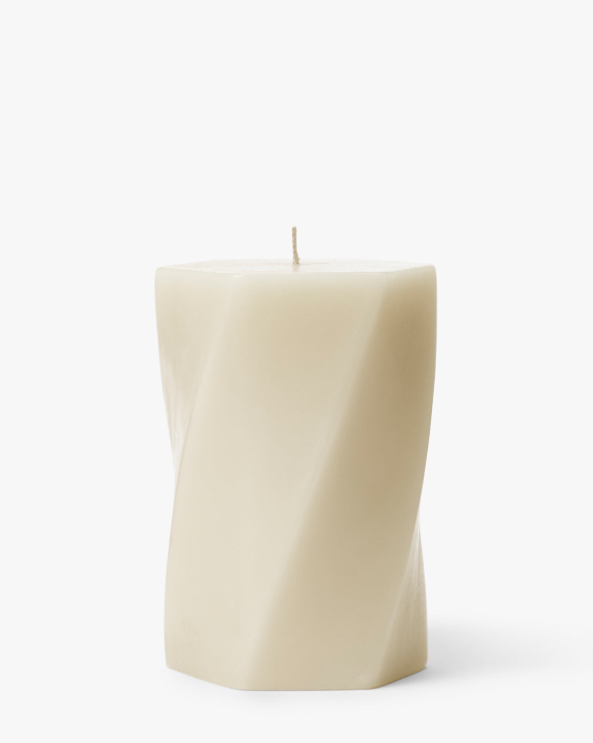 The Errol Wax Pillar Candle is a cream-colored, hexagonal candle featuring a subtle twisted design and a single wick on top, displayed against a plain white background by McGee & Co.