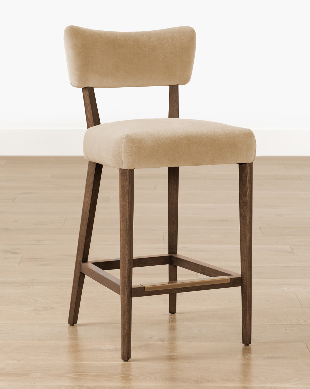 The Makerspalm Etienne Stool (Ready to Ship) features beige upholstery, a rectangular backrest and seat, wooden legs, and a footrest—ideal as a vintage-inspired accent for your kitchen or dining space. McGee & Co.