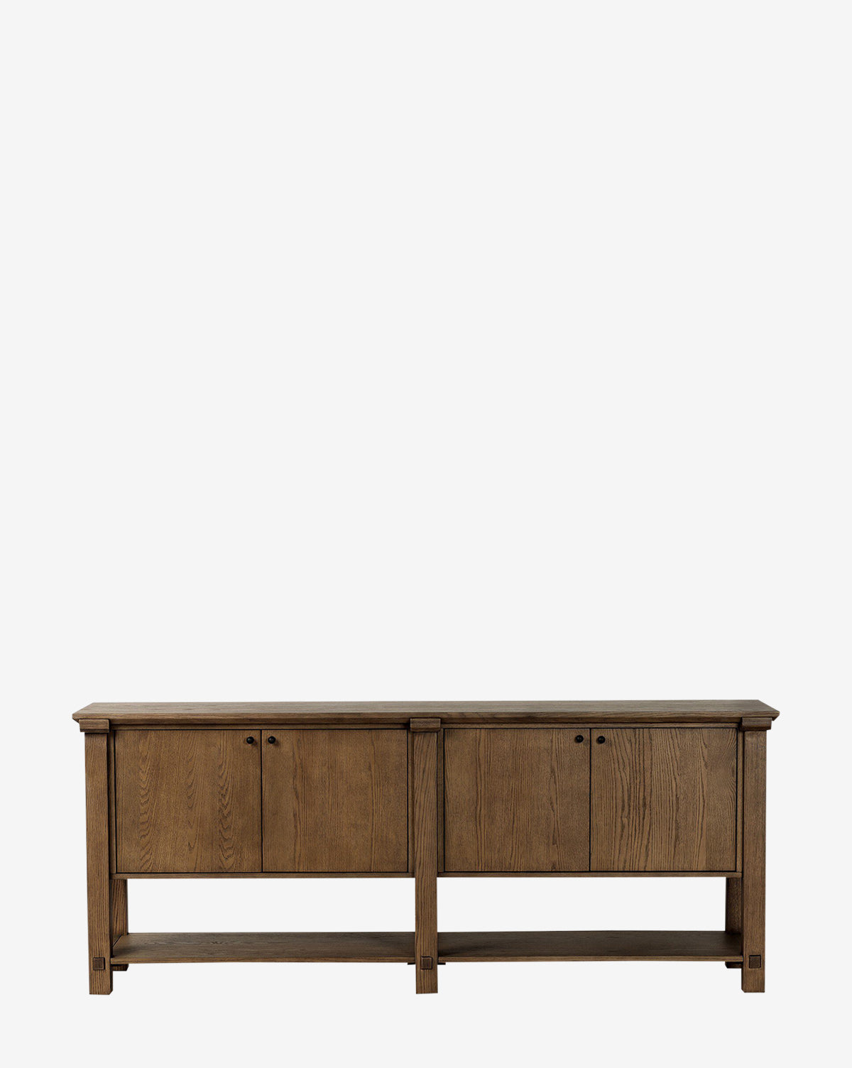 The Evaline Sideboard is a modern solid oak piece with a natural finish, featuring four cabinet doors with round handles and an open bottom shelf, shown against a plain white background by McGee & Co.