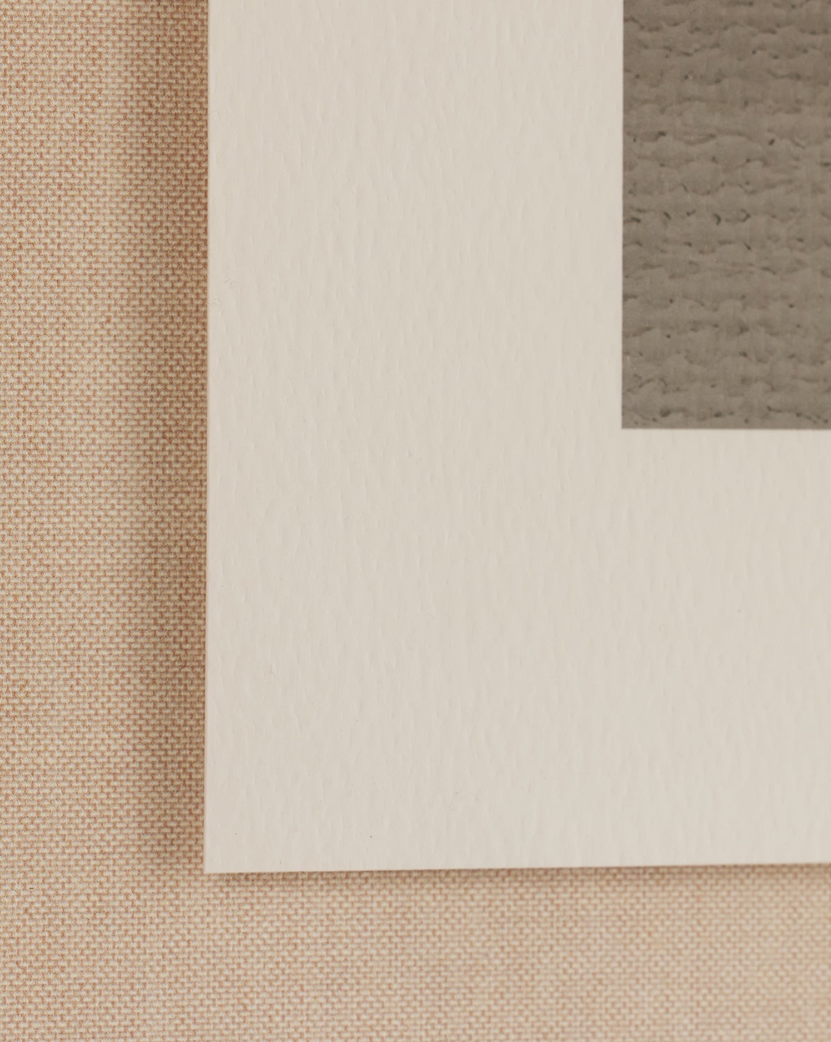 Close-up of the corner of Abstract Ombre No. 5 By Roseanne Kenny, showing a white mat board, the brownish edge of the artwork inside the mat, and a beige textured background hinting at fine art paper.
