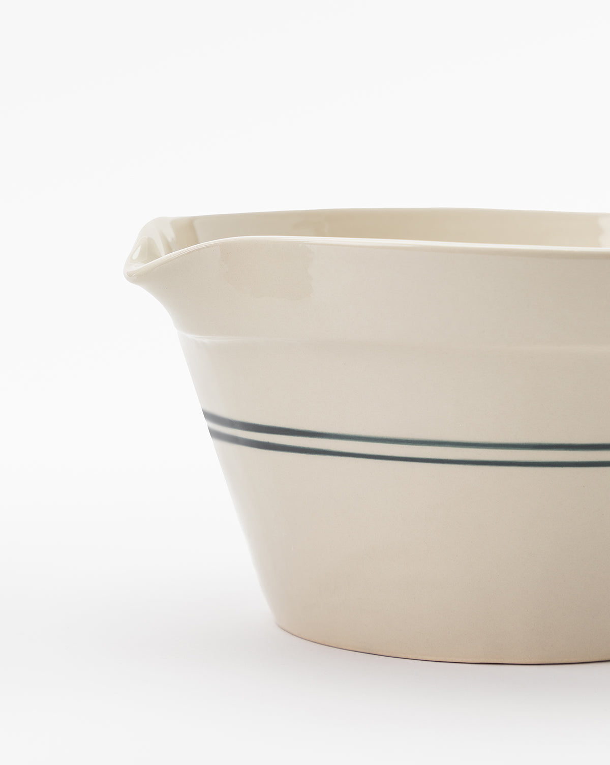 The Everett Mixing Bowl is beige with a small spout and two dark blue horizontal stripes near the middle, shown against a plain white background by McGee & Co.