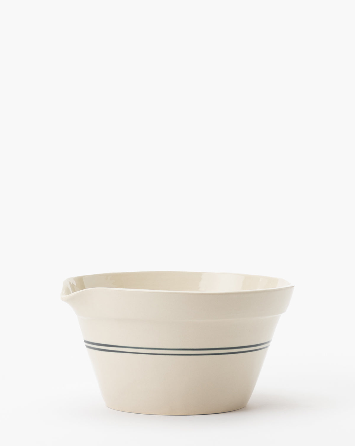 The Everett Mixing Bowl is a cream-colored ceramic bowl with a single dark blue stripe around the middle, featuring a convenient pouring spout on one side. Set against a plain white background, this vintage-style bowl combines function and style by McGee & Co.