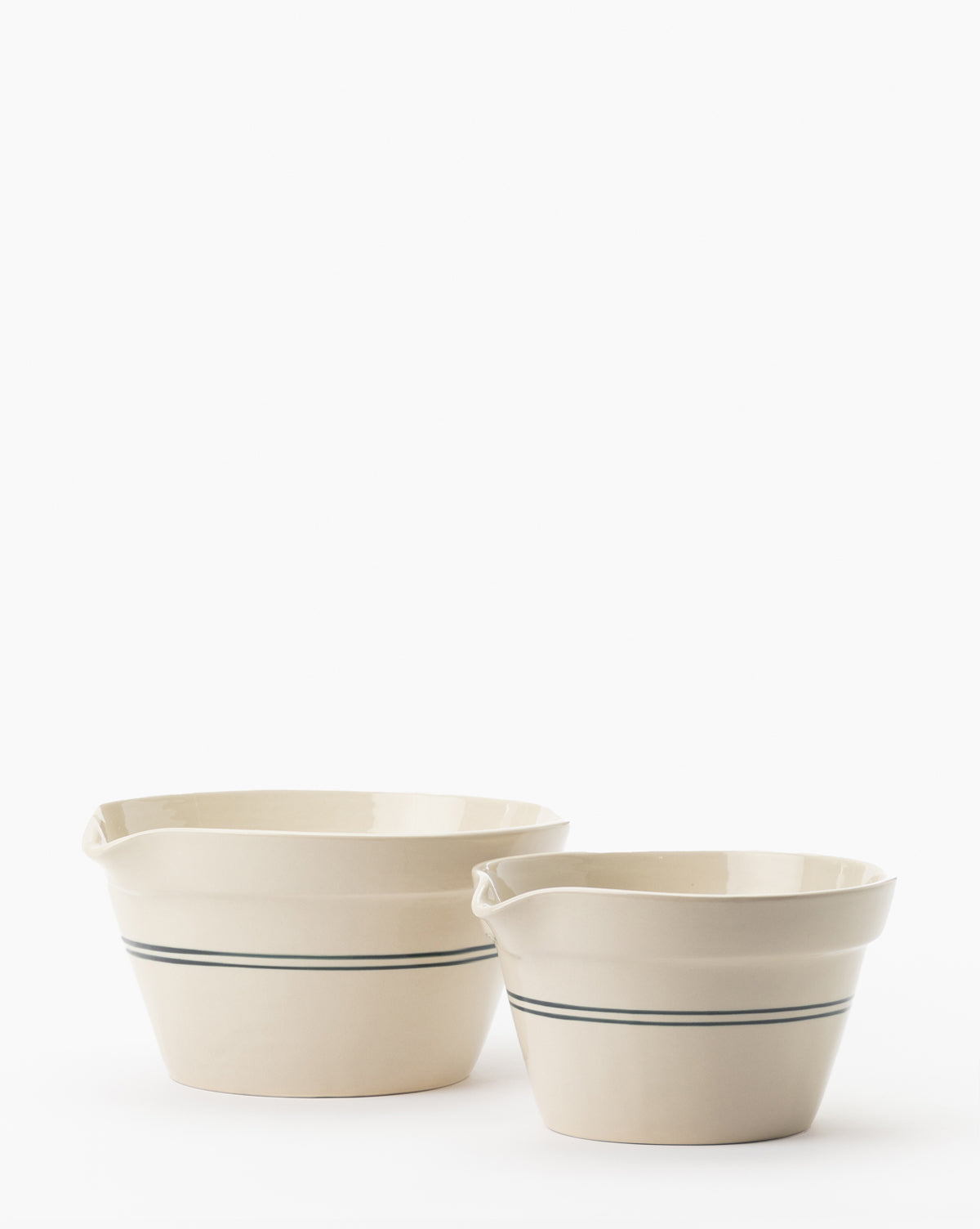 The Everett Mixing Bowl, a cream-colored ceramic bowl with pouring spout and thin blue stripe, is shown side by side with another on a white background by McGee & Co.