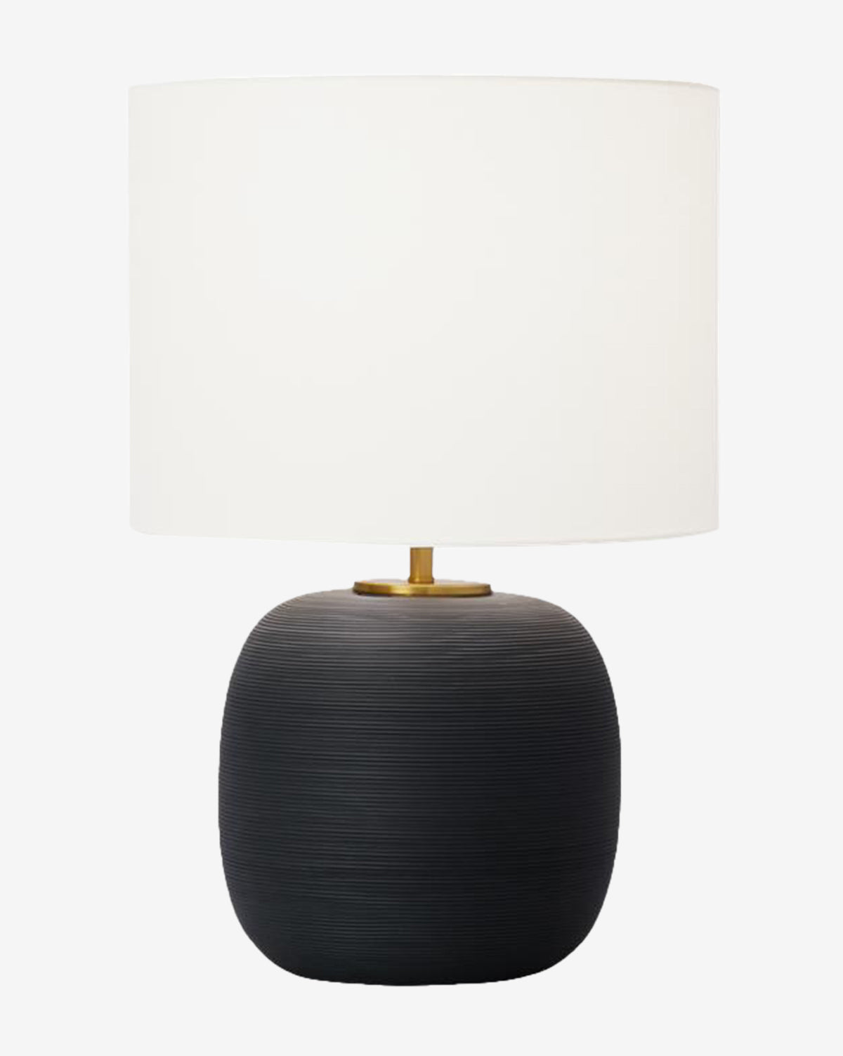 The Fanny Table Lamp has a large white drum shade, a rounded black ceramic base with a textured finish, and a gold accent at the top where the shade attaches, by McGee & Co.