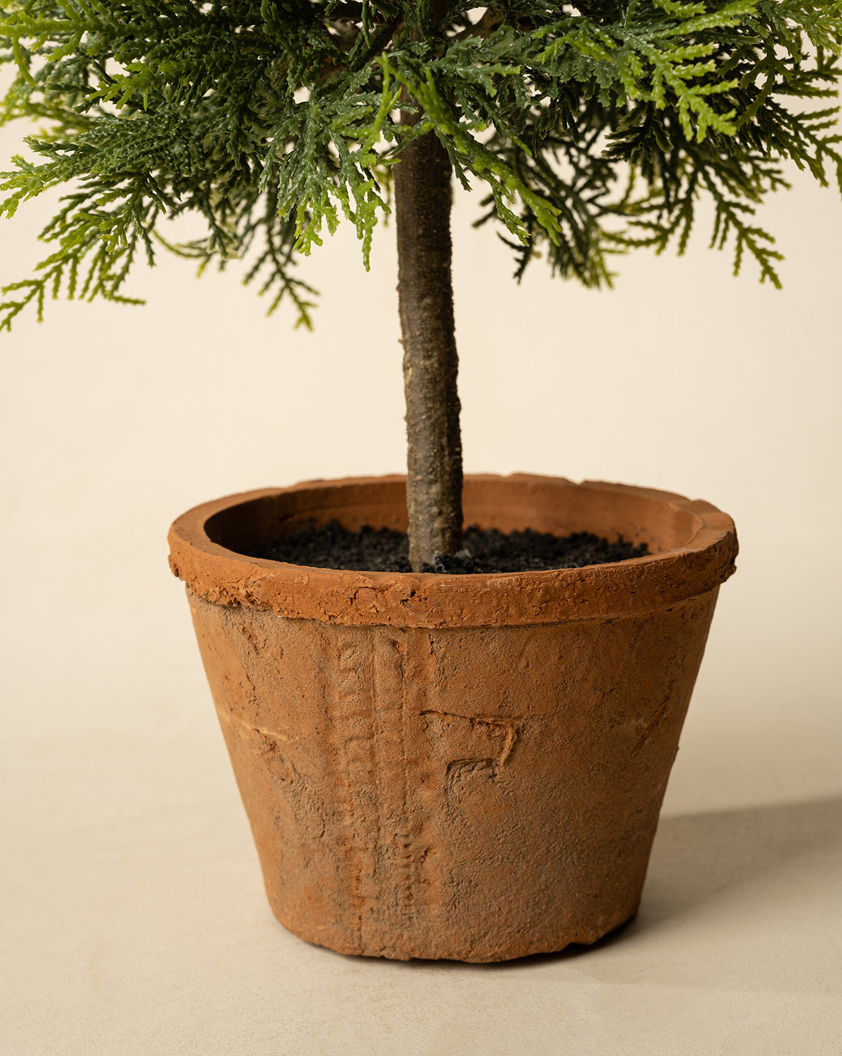The 15.5" Cypress Faux Potted Topiary features green needle-like leaves in a round, textured terracotta pot with dark soil, set against a light, neutral background, by McGee & Co.