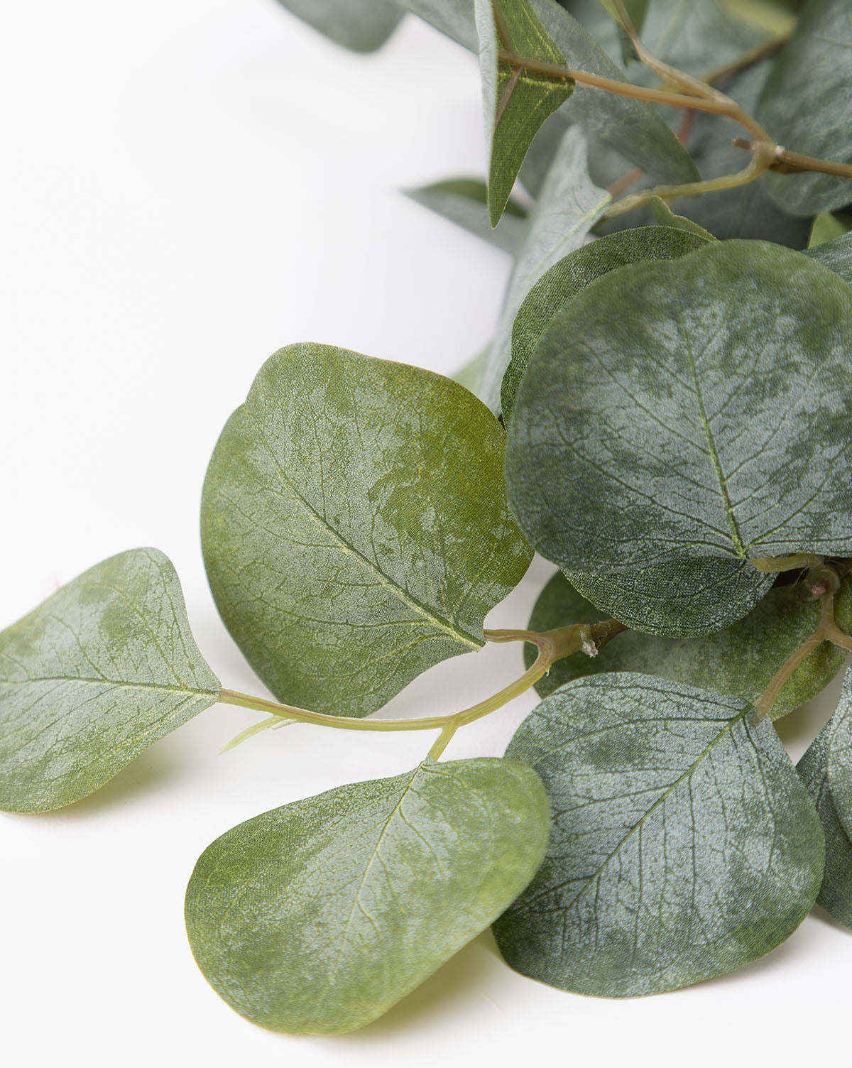 The Faux Eucalyptus Branch displays several green leaves with visible veins on thin stems and a slightly waxy texture—ideal for any vase arrangement.
