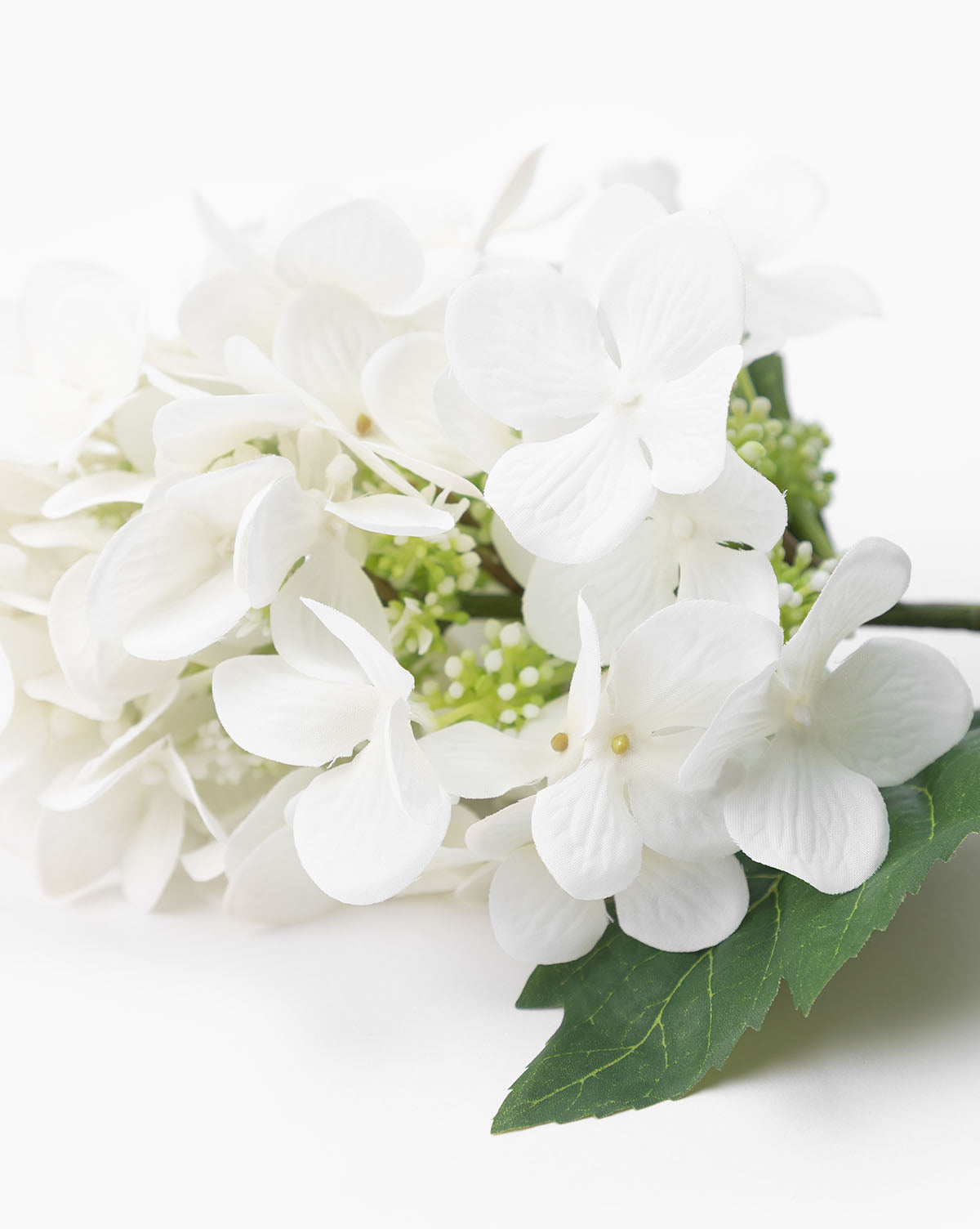 Close-up of a Faux Hydrangea Stem featuring artificial white flowers with delicate petals and green leaves, ideal for decorative vase arrangements, set against a plain white background.