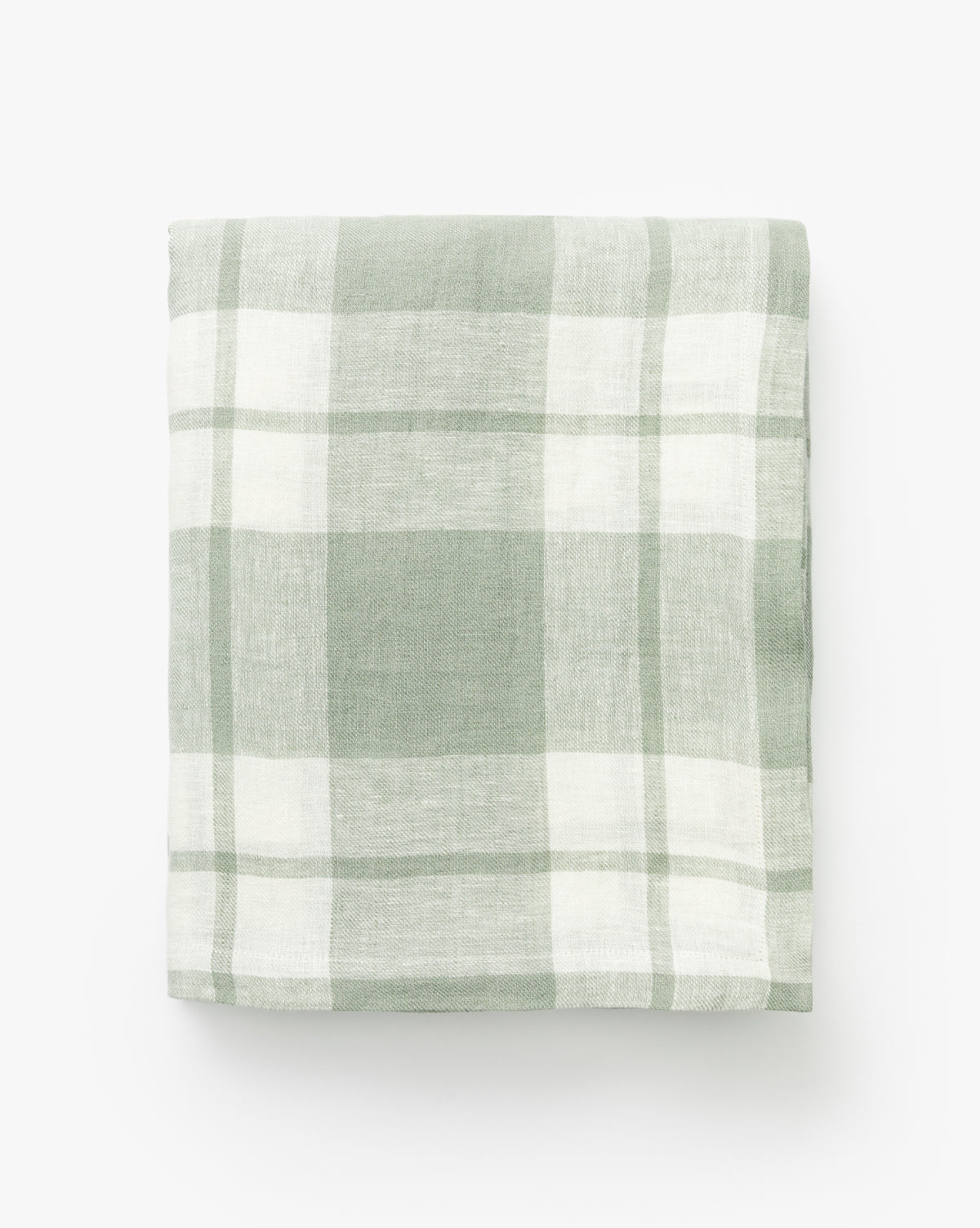 The Felix Plaid Tablecloth, neatly folded in light green and white plaid, is displayed against a plain white background by McGee & Co.