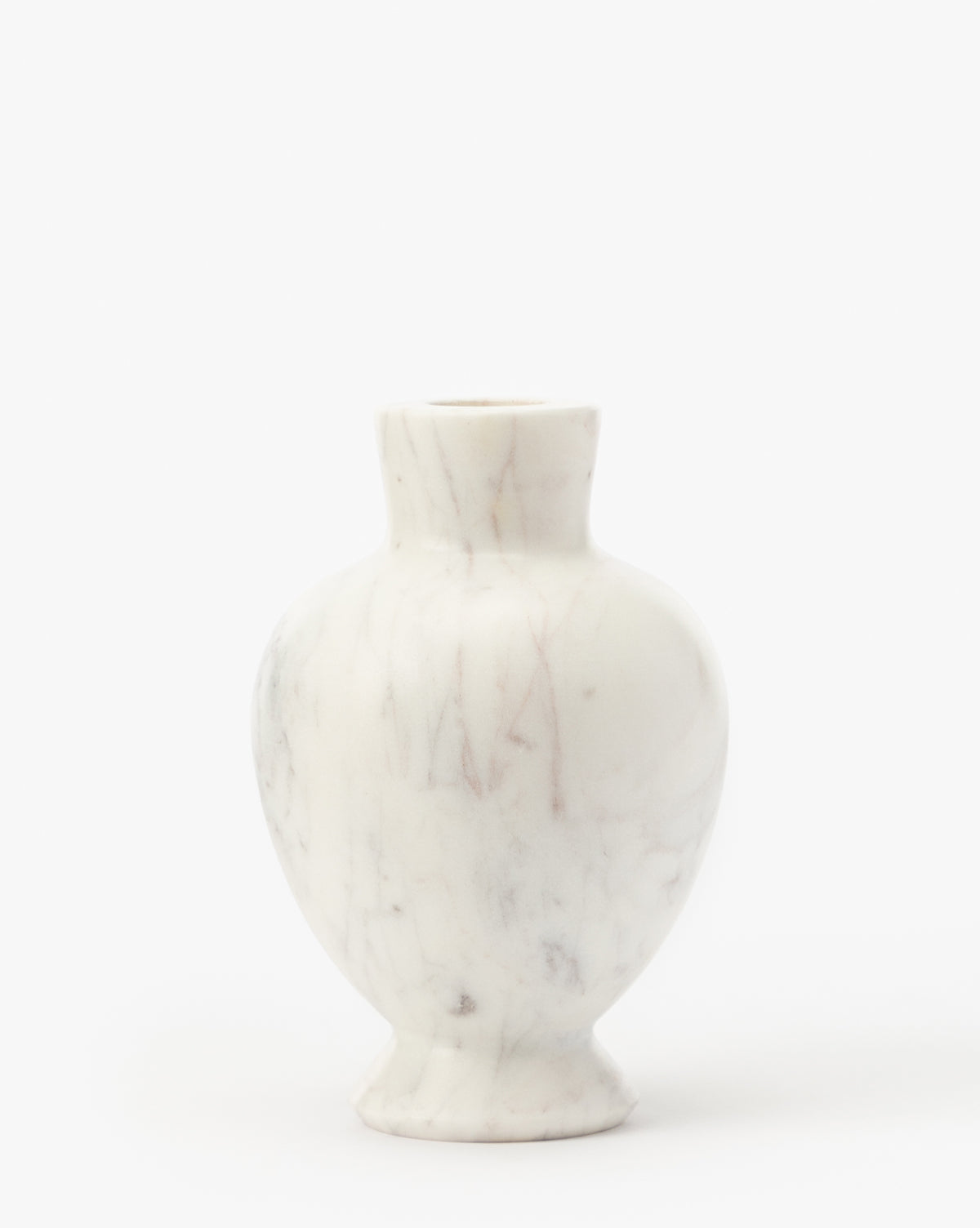 The Fera Bud Vase is a small, white marble vase featuring a rounded body, narrow neck, and subtle gray veining, displayed against a plain white background, by McGee & Co.
