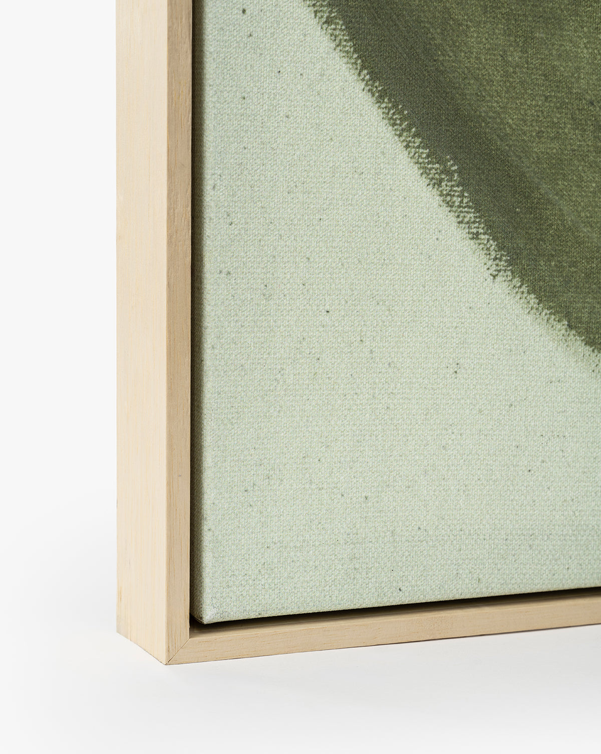 Close-up of the light wood frame on Fields of Green canvas wall art, showcasing abstract green and beige artwork with soft, textured brushstrokes. The canvas edge fits neatly within the frame, by McGee & Co.