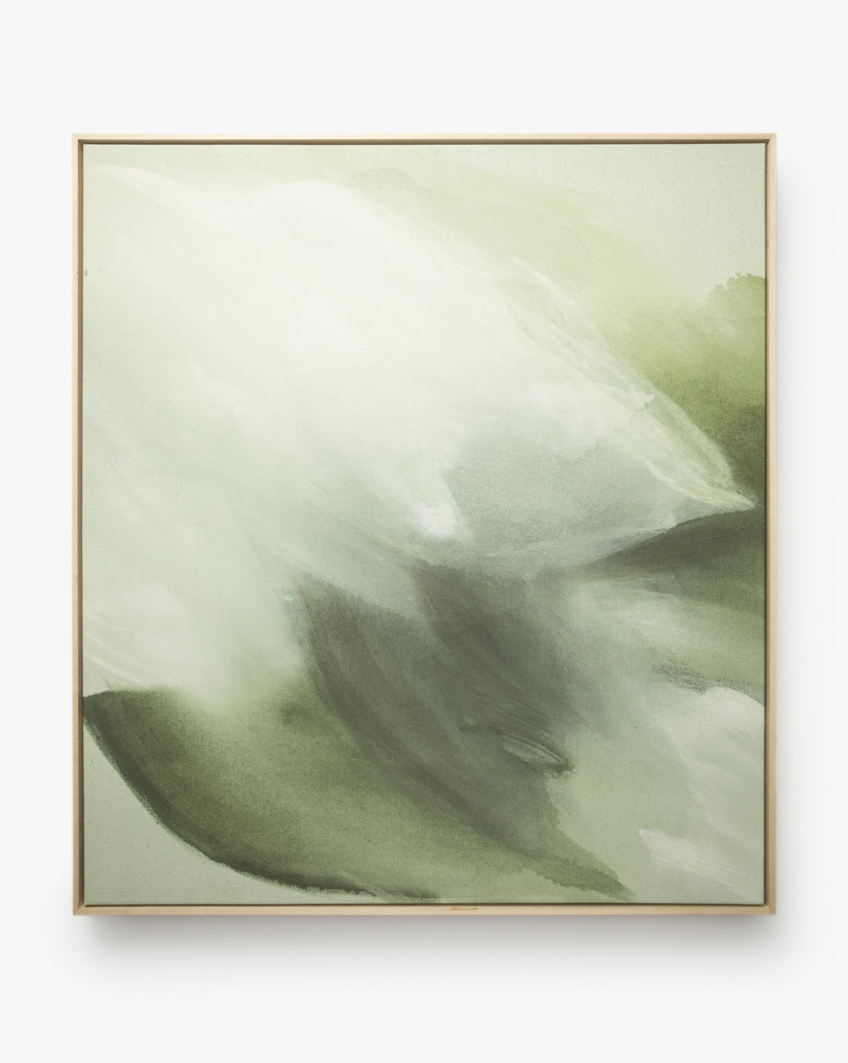 Fields of Green features abstract art with soft green, white, and gray brushstrokes blending for a calming effect, beautifully framed in light wood, by McGee & Co.