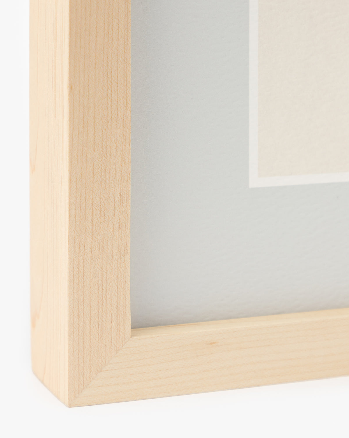 Close-up of the bottom left corner of Finn, a light wood picture frame with a smooth finish and clean miter joint. It displays a light mat and Scottish Terrier sketch—ideal as dog wall art or for nursery decor by McGee & Co.